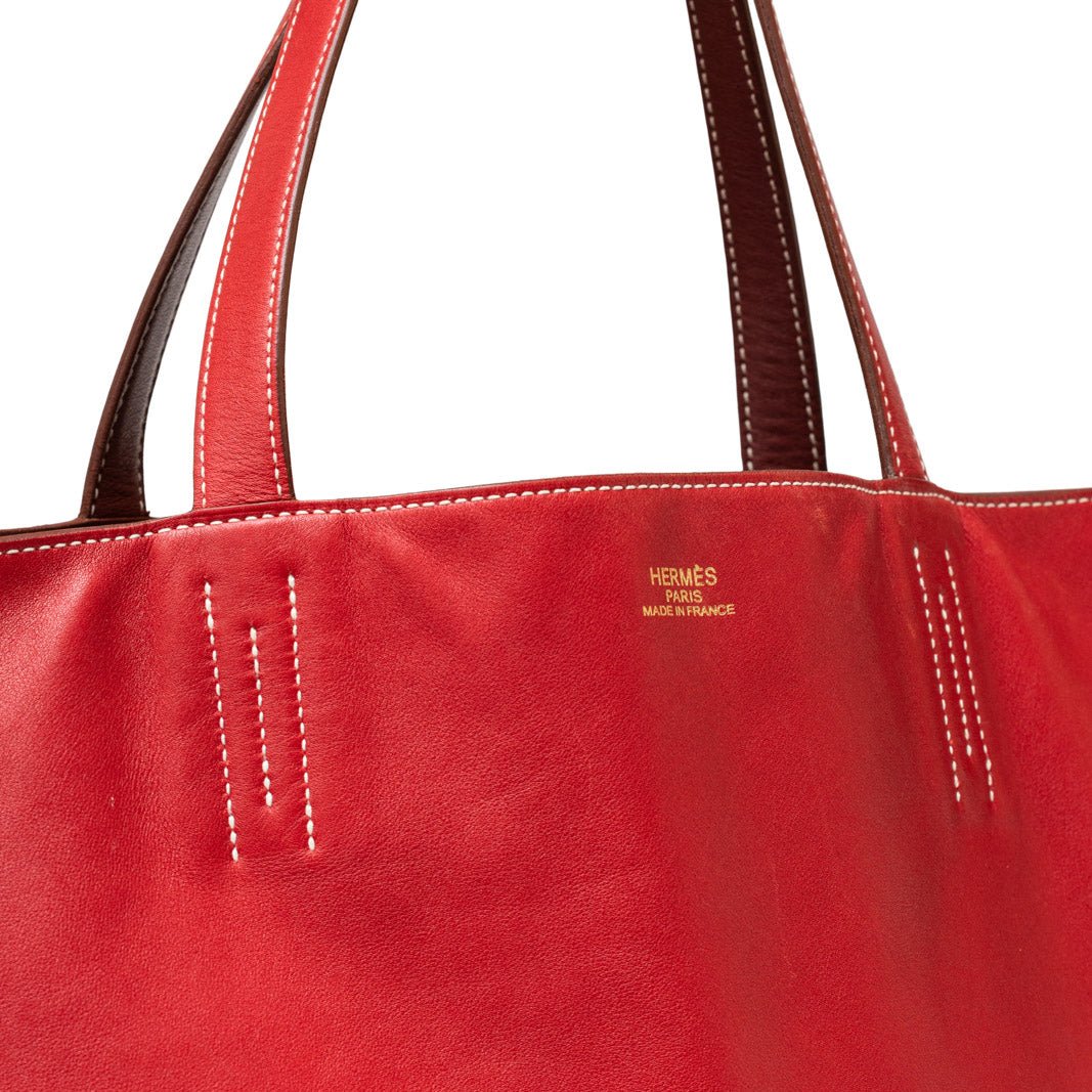 Close-up of red Hermès Double Sens 45 Rouge/Bicolor Swift tote showing smooth leather and contrast stitching detail