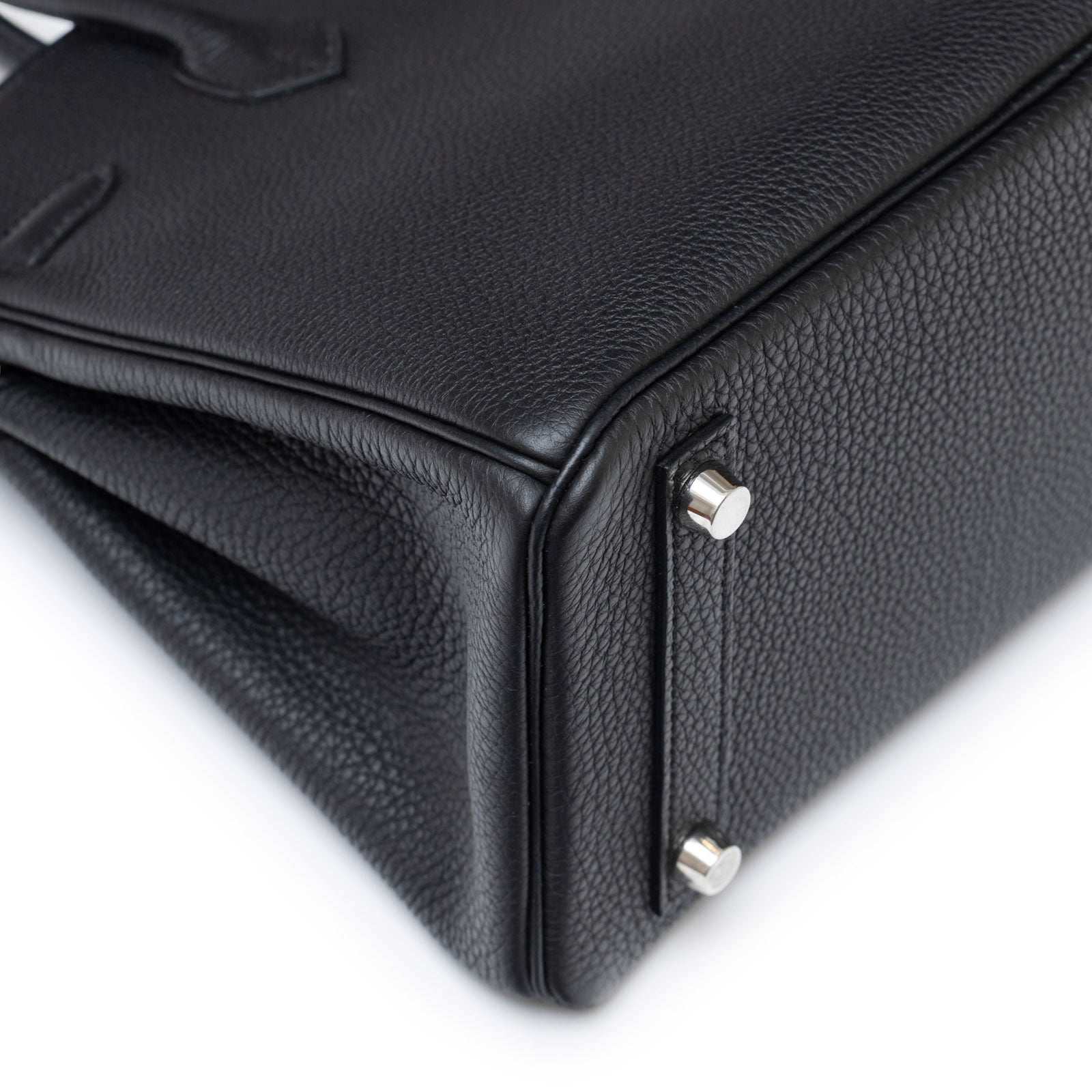 Close-up of bottom corner showing textured black leather and palladium hardware on Hermès Birkin 25 Black Togo Palladium Hardware