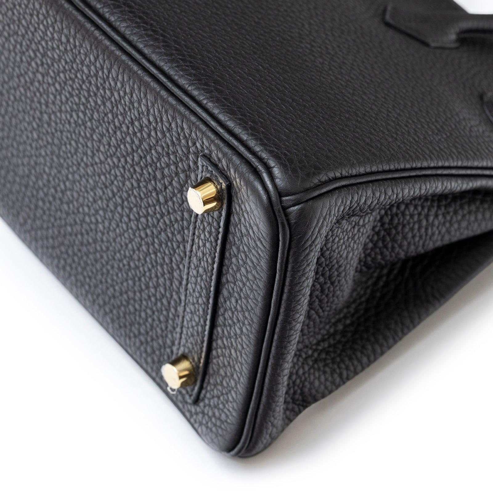 Close-up bottom view of Hermès Birkin 25 Black Togo Gold Hardware showing textured leather and gold feet studs