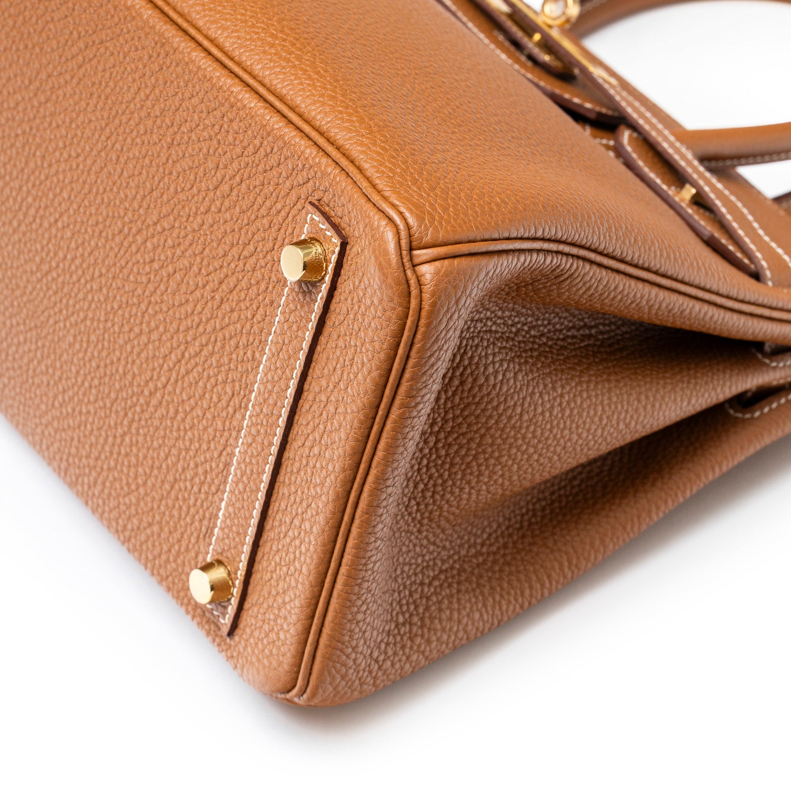Close-up angled shot of Hermès Birkin 30 Gold Togo Gold Hardware showing base corner and feet details