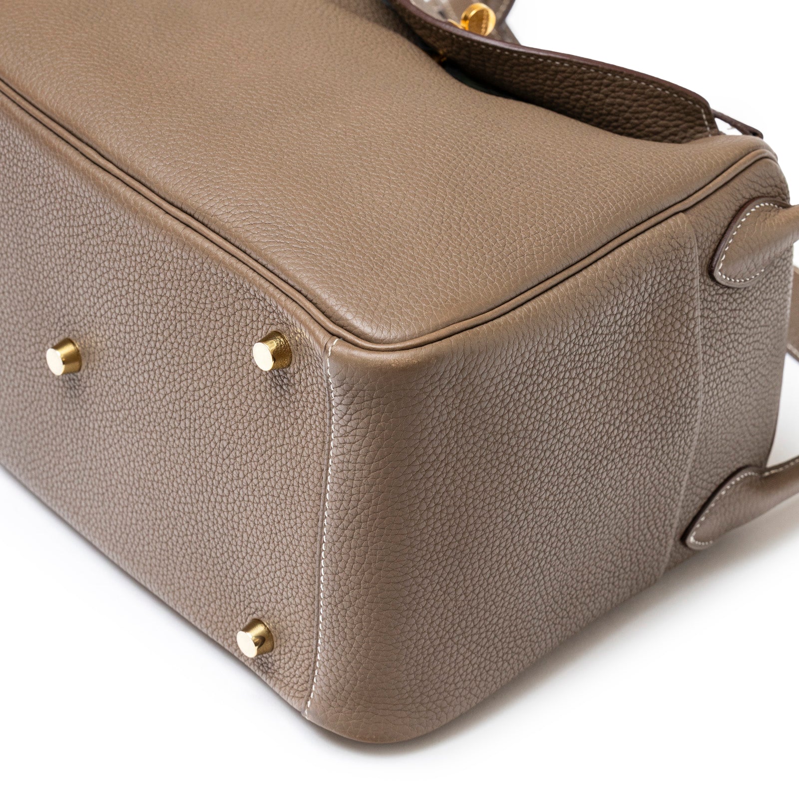 Close-up bottom view of Hermès Lindy 30 Etoupe Clemence Gold Hardware showing leather texture and feet detail