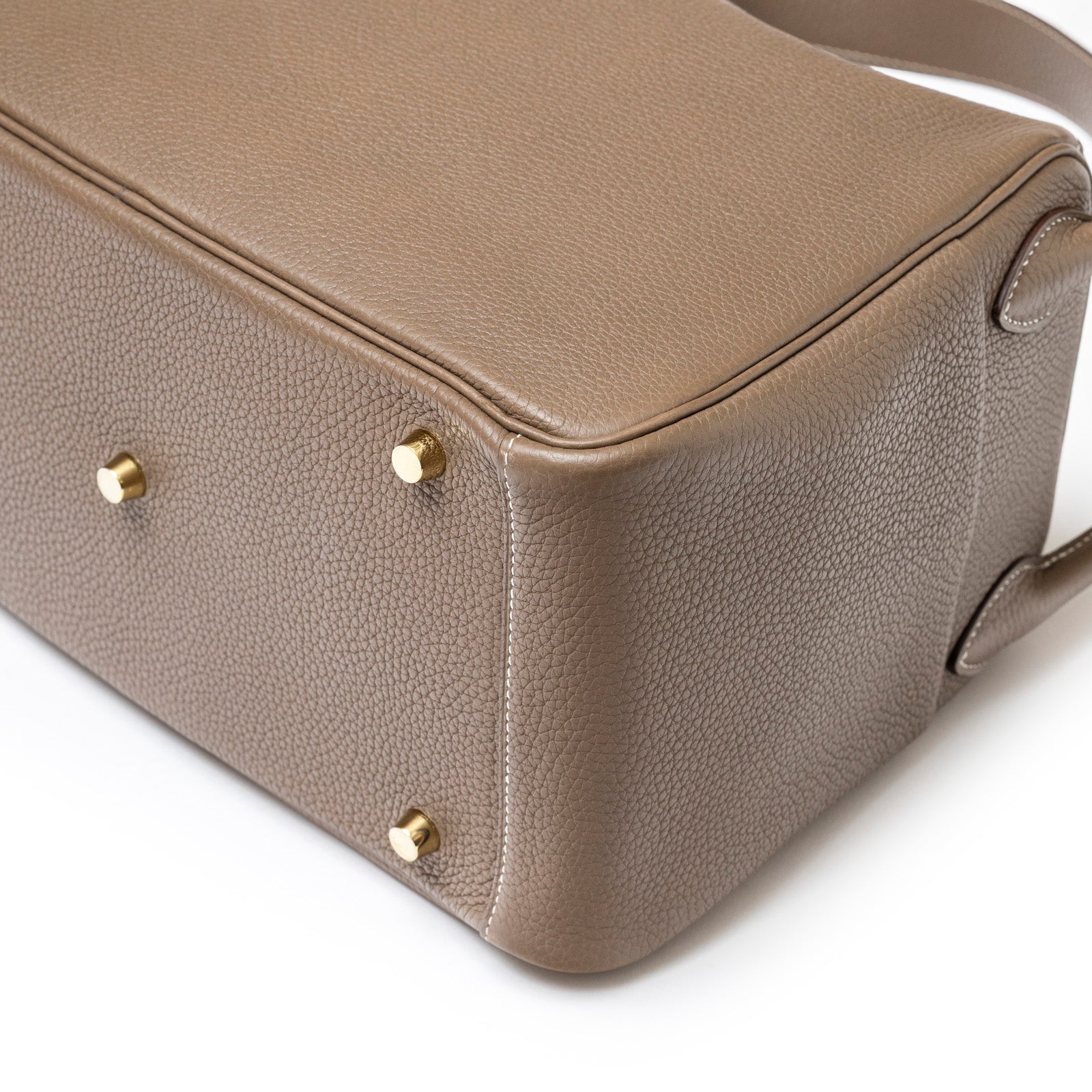 Close-up of base and gold hardware feet on Hermès Lindy 30 Etoupe Clemence Gold Hardware handbag