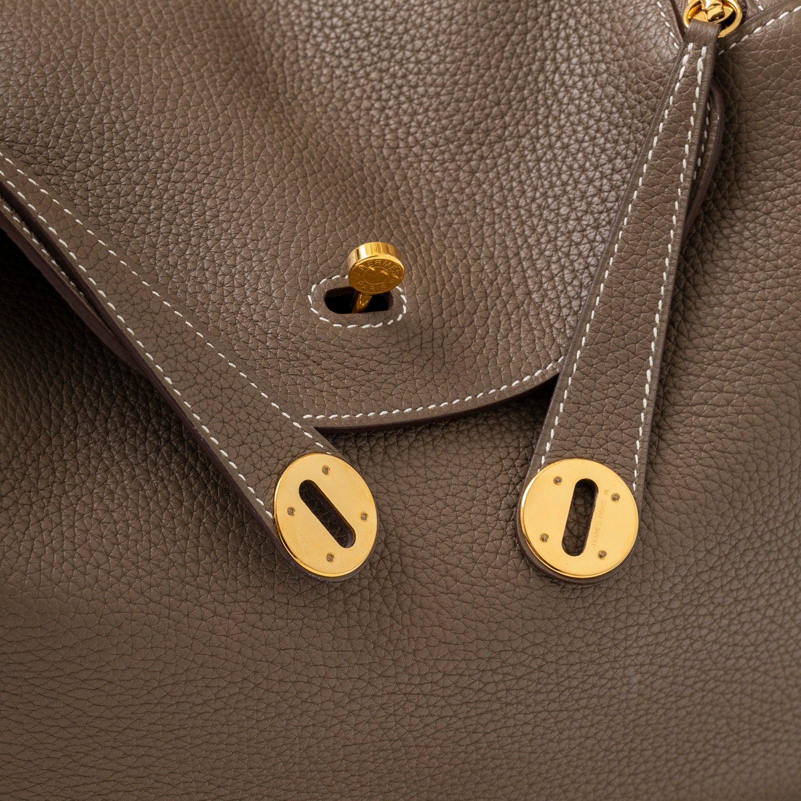 Close-up of gold hardware and Etoupe Clemence leather stitching on Hermès Lindy 30 Etoupe Clemence Gold Hardware bag