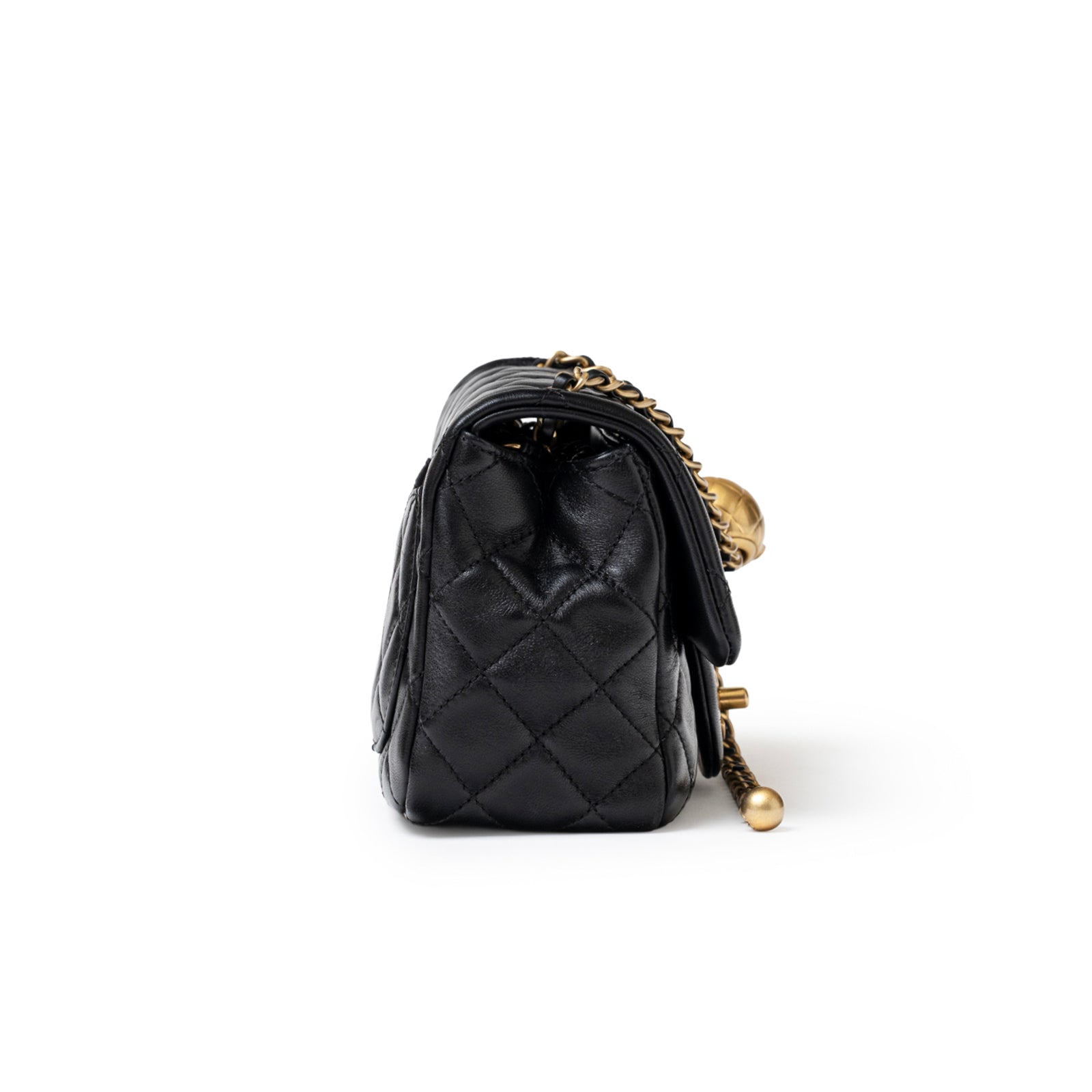 Side view of Chanel Mini Square Pearl Crush Flap Bag Black Lambskin Aged Brushed Gold Hardware showing quilted texture and chain details