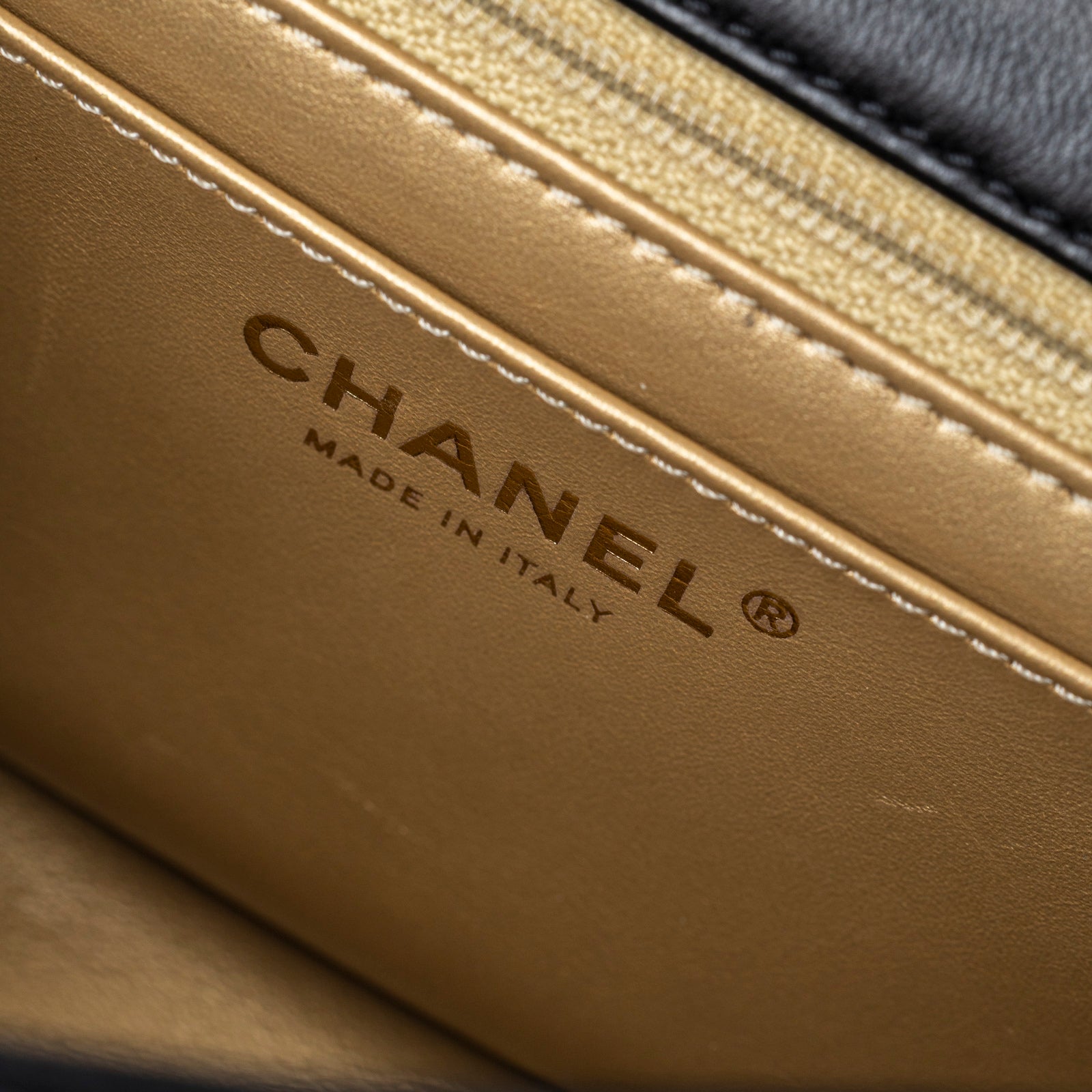 Close-up of Chanel Mini Square Pearl Crush Flap Bag Black Lambskin Aged Brushed Gold Hardware interior logo tag made in Italy