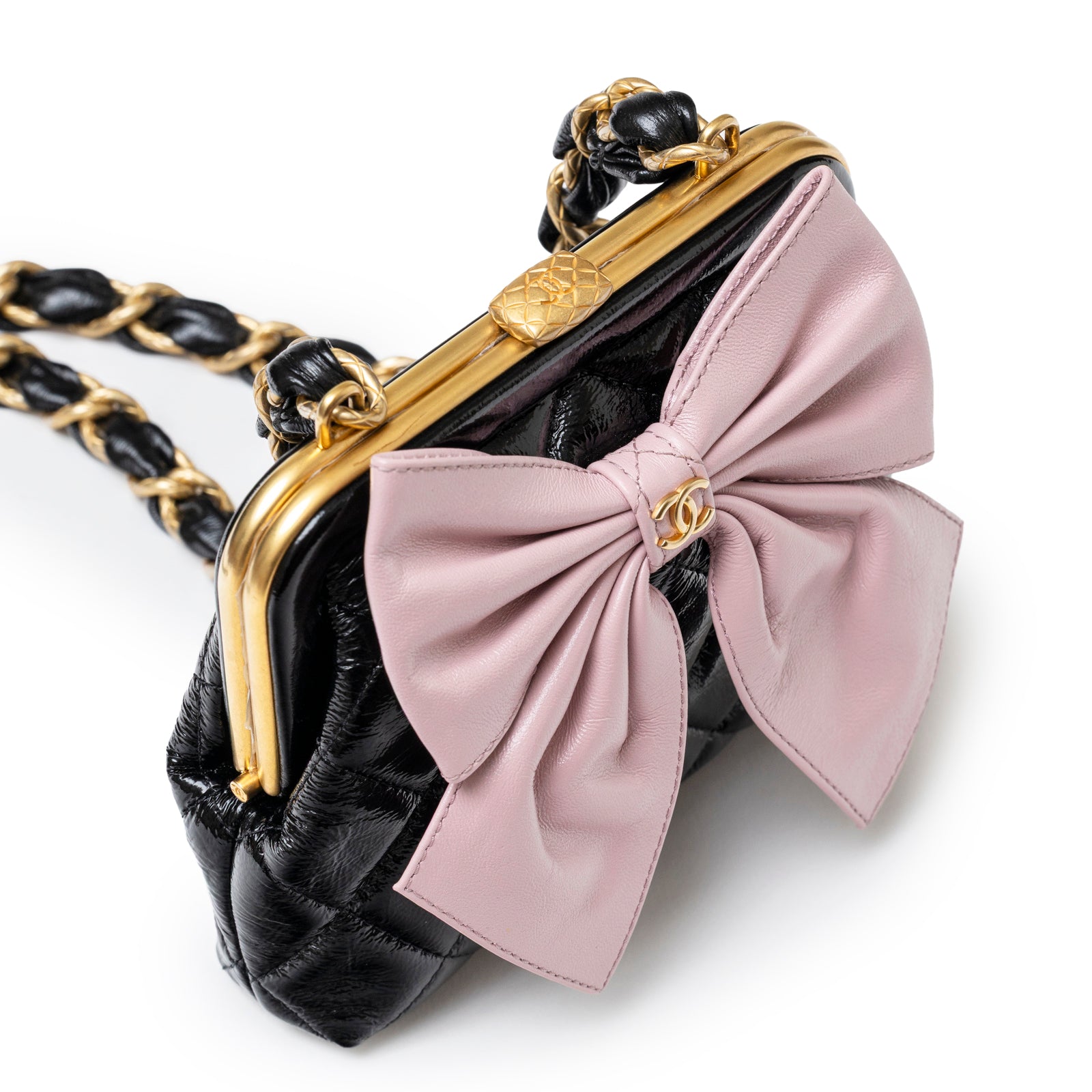 Angled close-up of Chanel Maxi Bow Clutch With Chain Black/Pink Shiny Quilted Patent Crumpled/Lambskin Brushed Gold Hardware showing bow detail