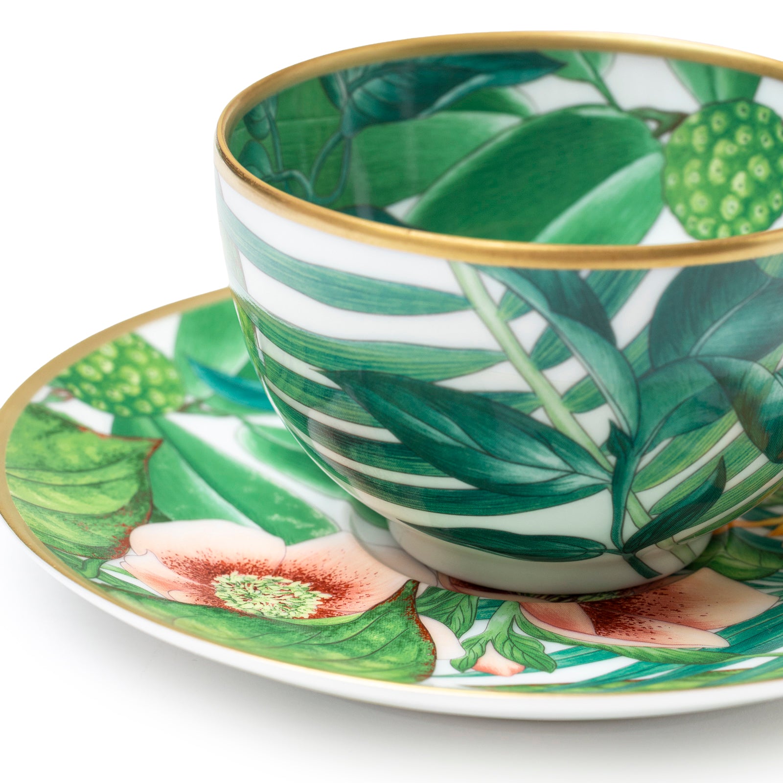 Close-up angled view of Hermès Passifolia Porcelain Tea Cup and Saucer Green & White 24K Gold & Porcelain Set of 2 showing leaf and flower design