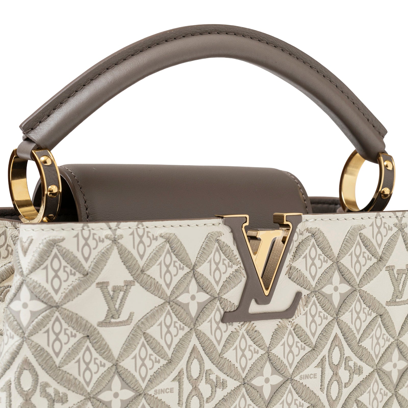 Close-up front view of Louis Vuitton Since 1854 Embroidered Capucines BB Ecru/Taupe Calf Gold Hardware handle and logo detail