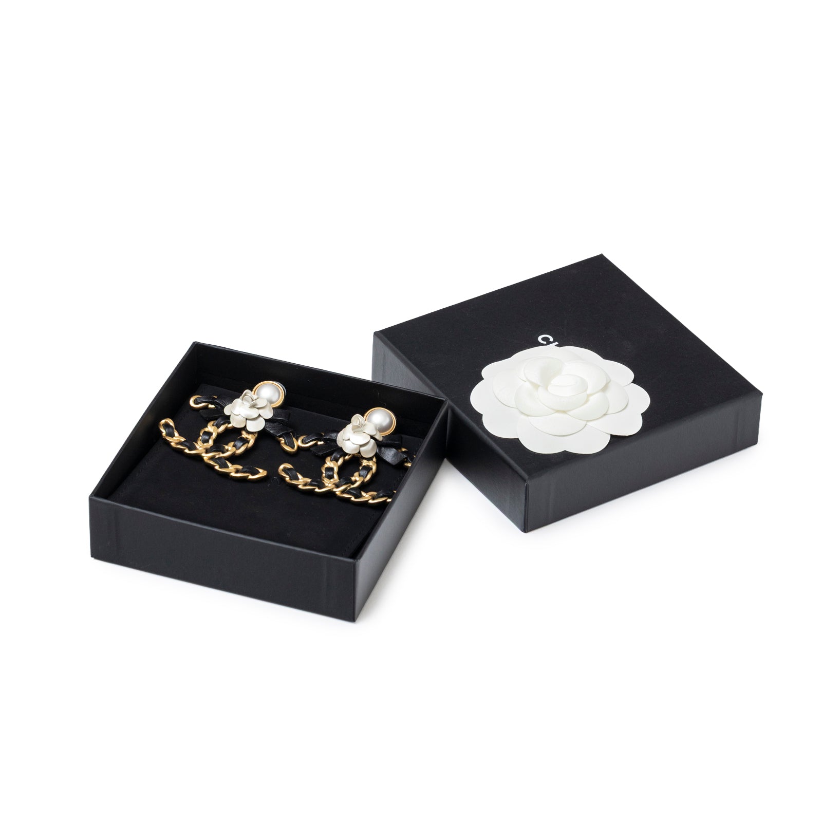 Chanel Black Bow With Camellia CC Earrings Gold Hardware displayed in original black box with white camellia detail top view