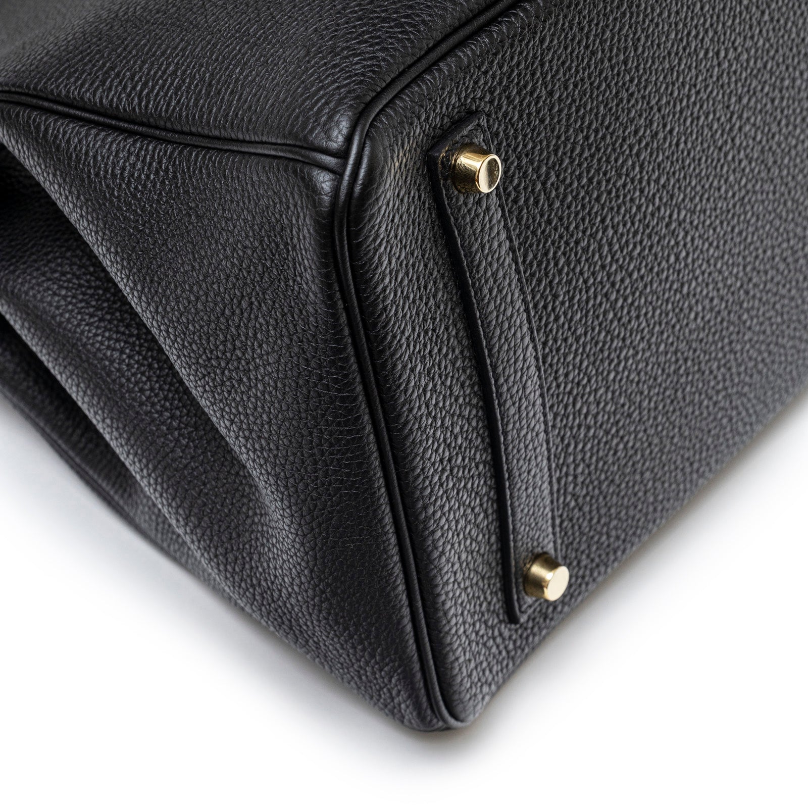 Close-up of bottom corner with gold feet on Hermès Birkin 35 Black Togo Gold Hardware handbag showing textured leather