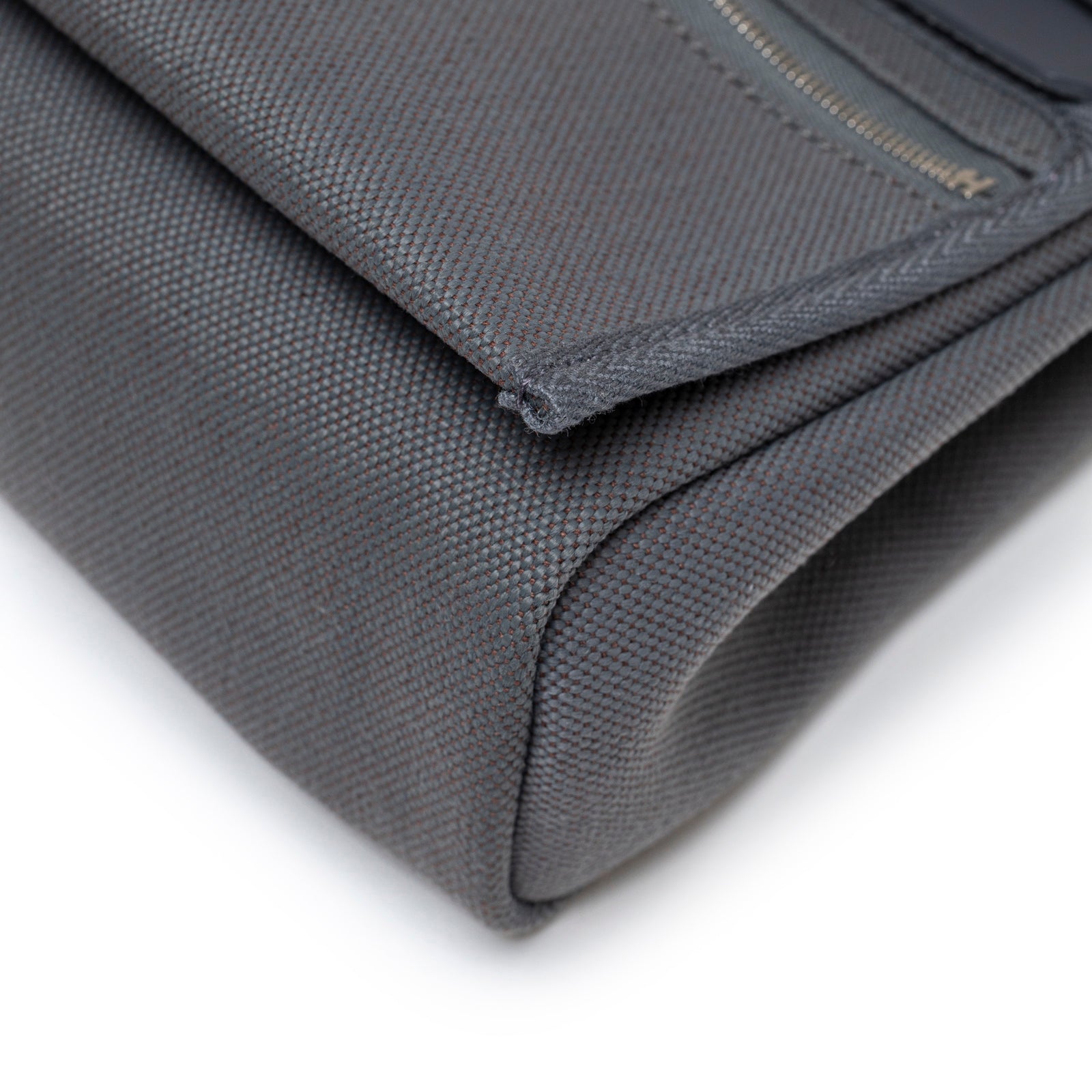 Close-up angled view of bottom corner on Hermès Mini Herbag Zip 20 Ardoise Toile and Vache Hunter Palladium Hardware showing canvas texture