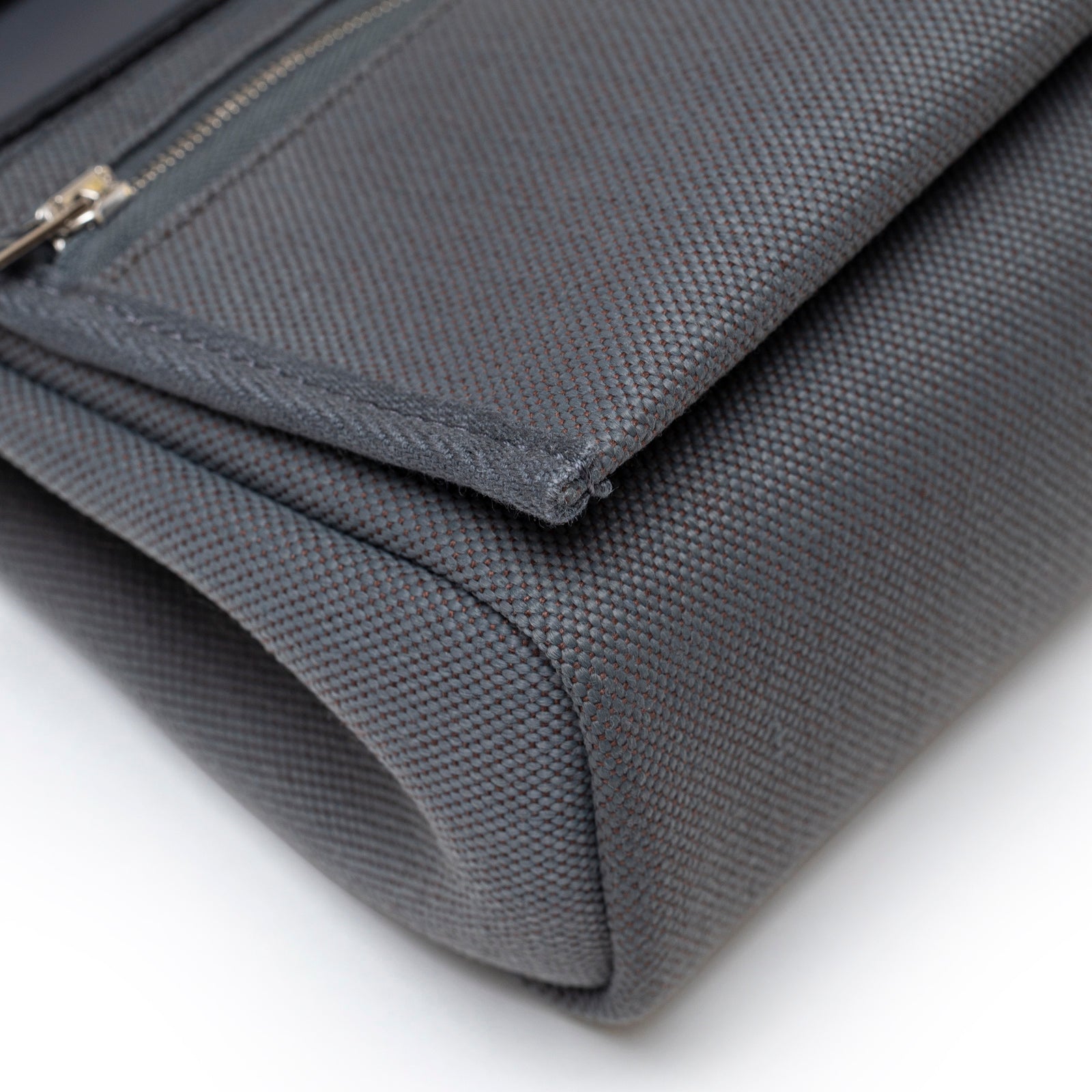 Close-up angled view of Hermès Mini Herbag Zip 20 Ardoise Toile and Vache Hunter Palladium Hardware corner stitching and textile texture detail