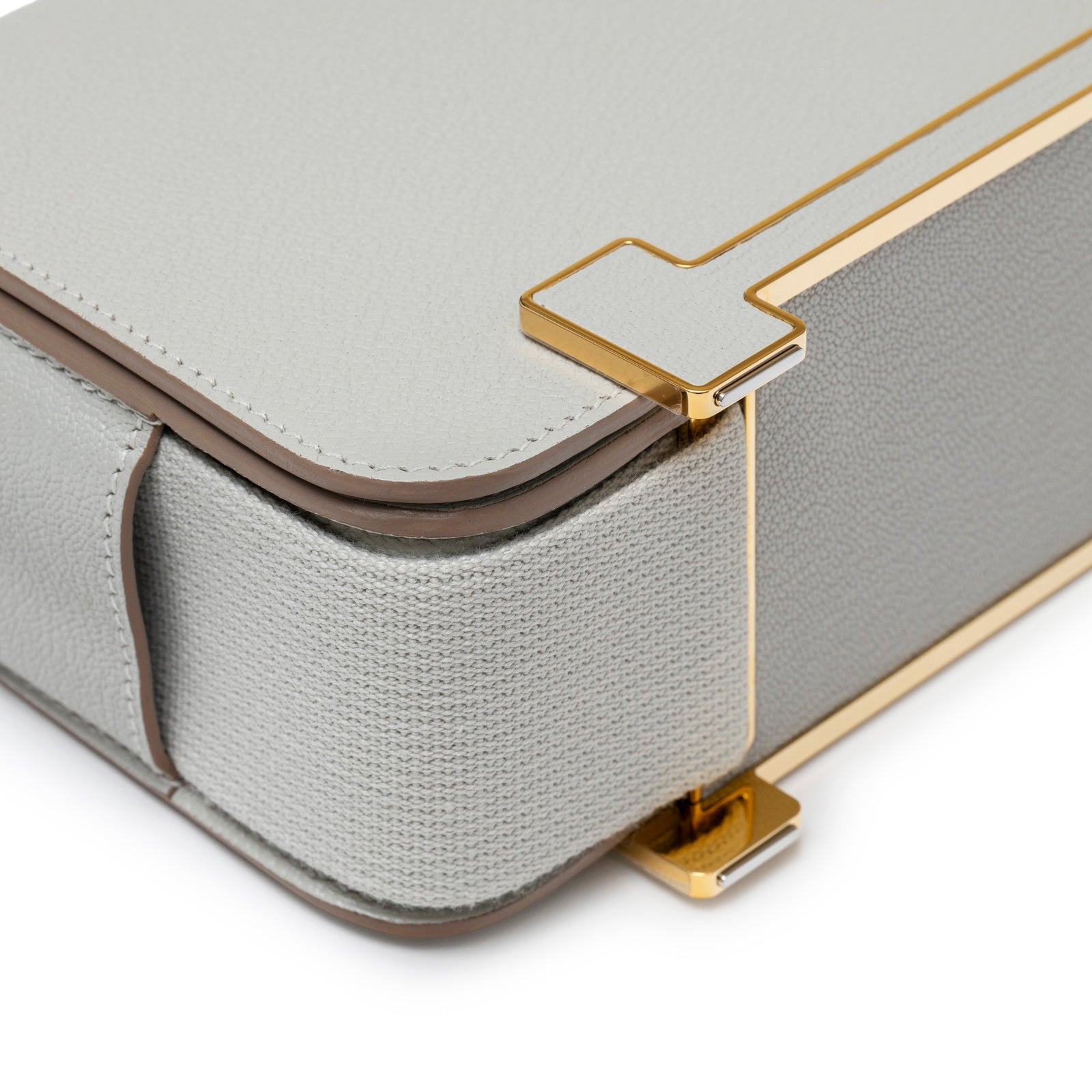 Close-up of corner showing gold hardware and textured material of Hermès Geta Gris Perle Chevre Mysore Gold Hardware bag