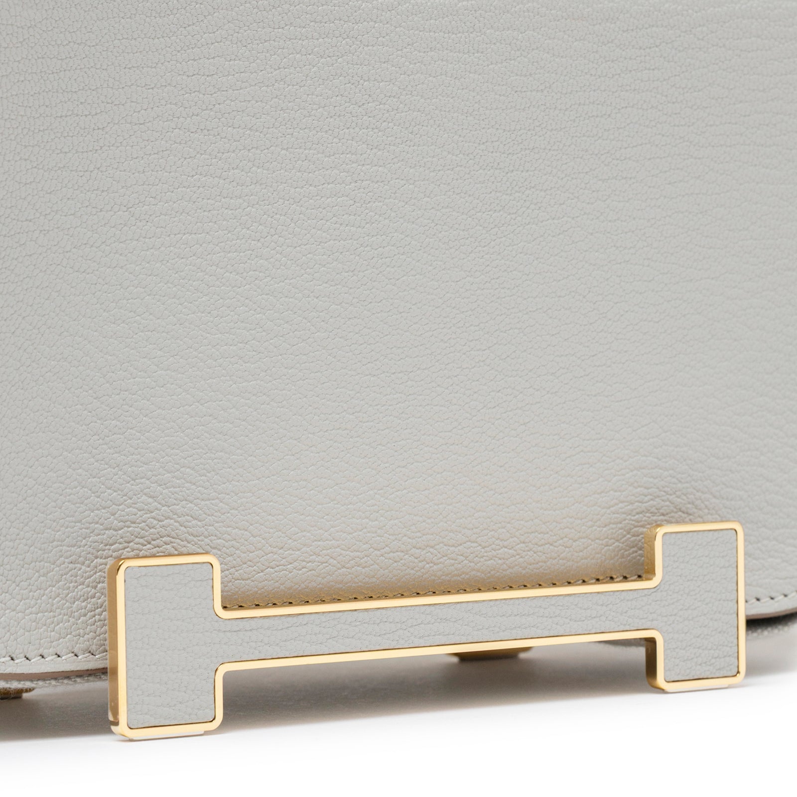 Close-up of gold hardware detail on Hermès Geta Gris Perle Chevre Mysore Gold Hardware handbag front flap