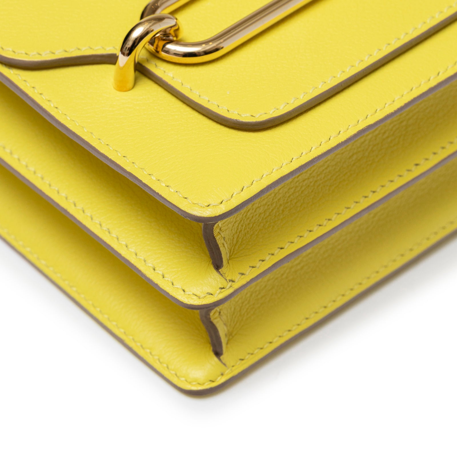 Close-up angled shot of Hermès Mini Roulis Lime Evercolor Permabrass Hardware corner and stitching detail