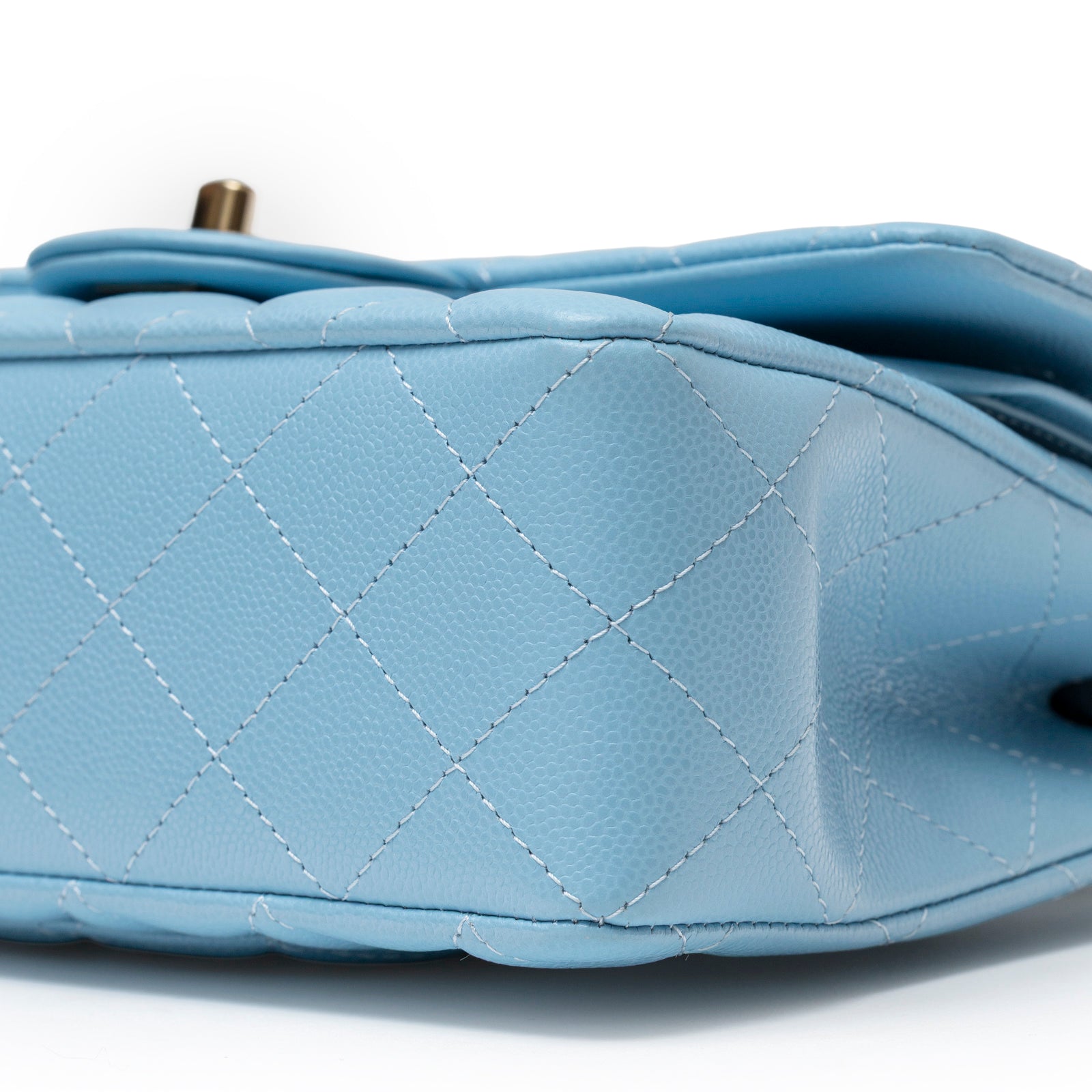 Close-up side view of Chanel Small Classic Flap Bag Blue Caviar Light Gold Hardware showing textured stitching and base details