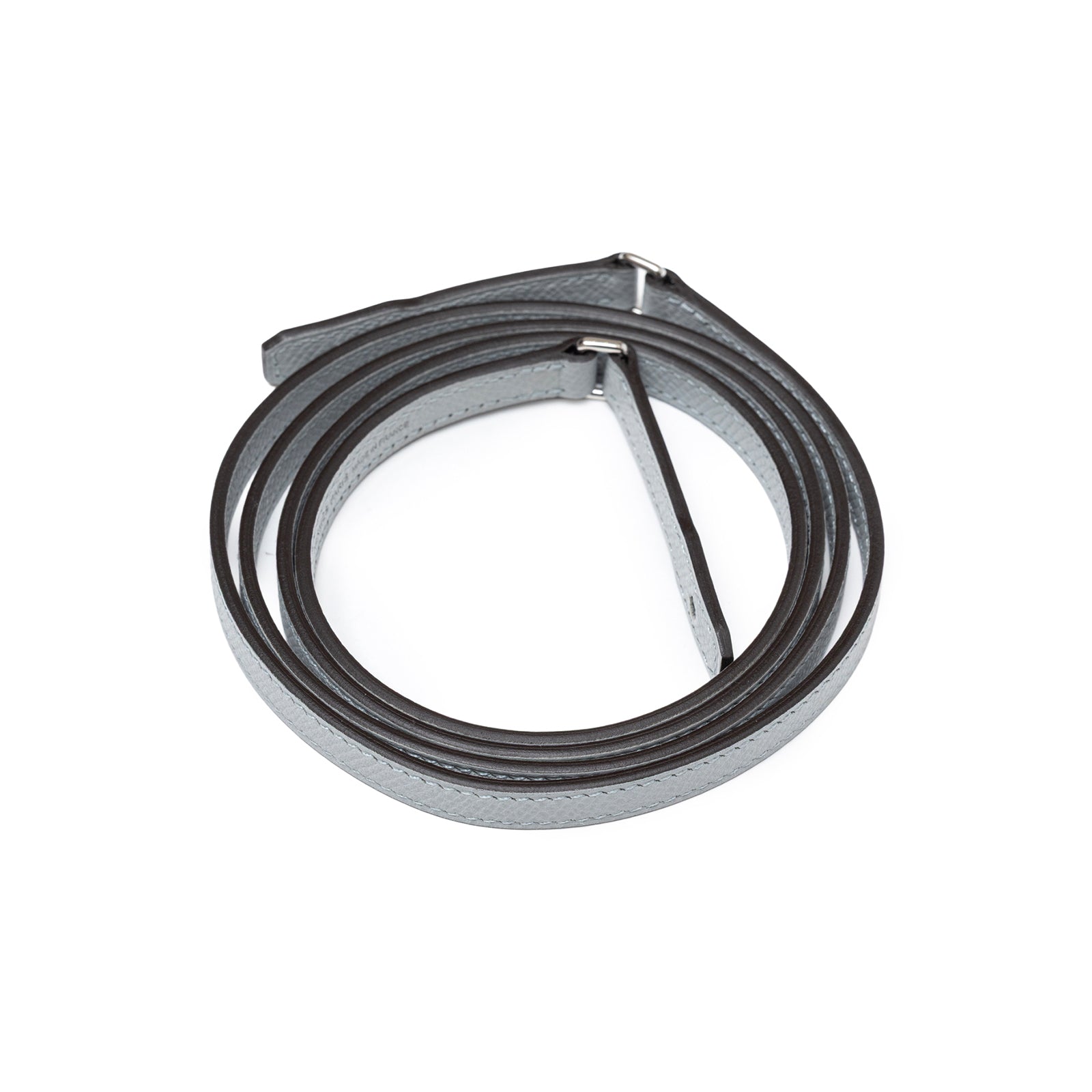 Coiled shoulder strap of Hermès Kelly To Go Wallet Blue Glacier Epsom Palladium Hardware on white background