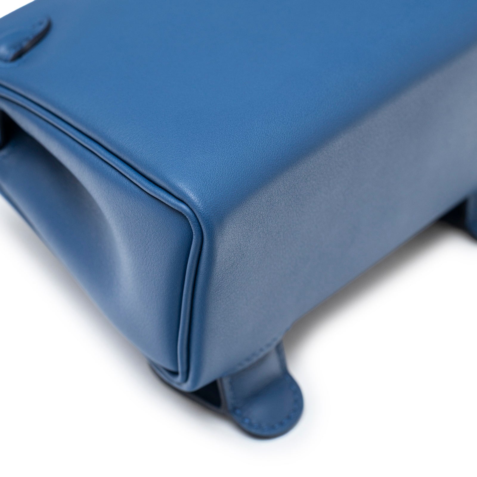 Close-up of bottom corner and stitching on Hermès Quelle Idolle Kelly Doll Bleu Tie and Caban Swift Palladium Hardware bag