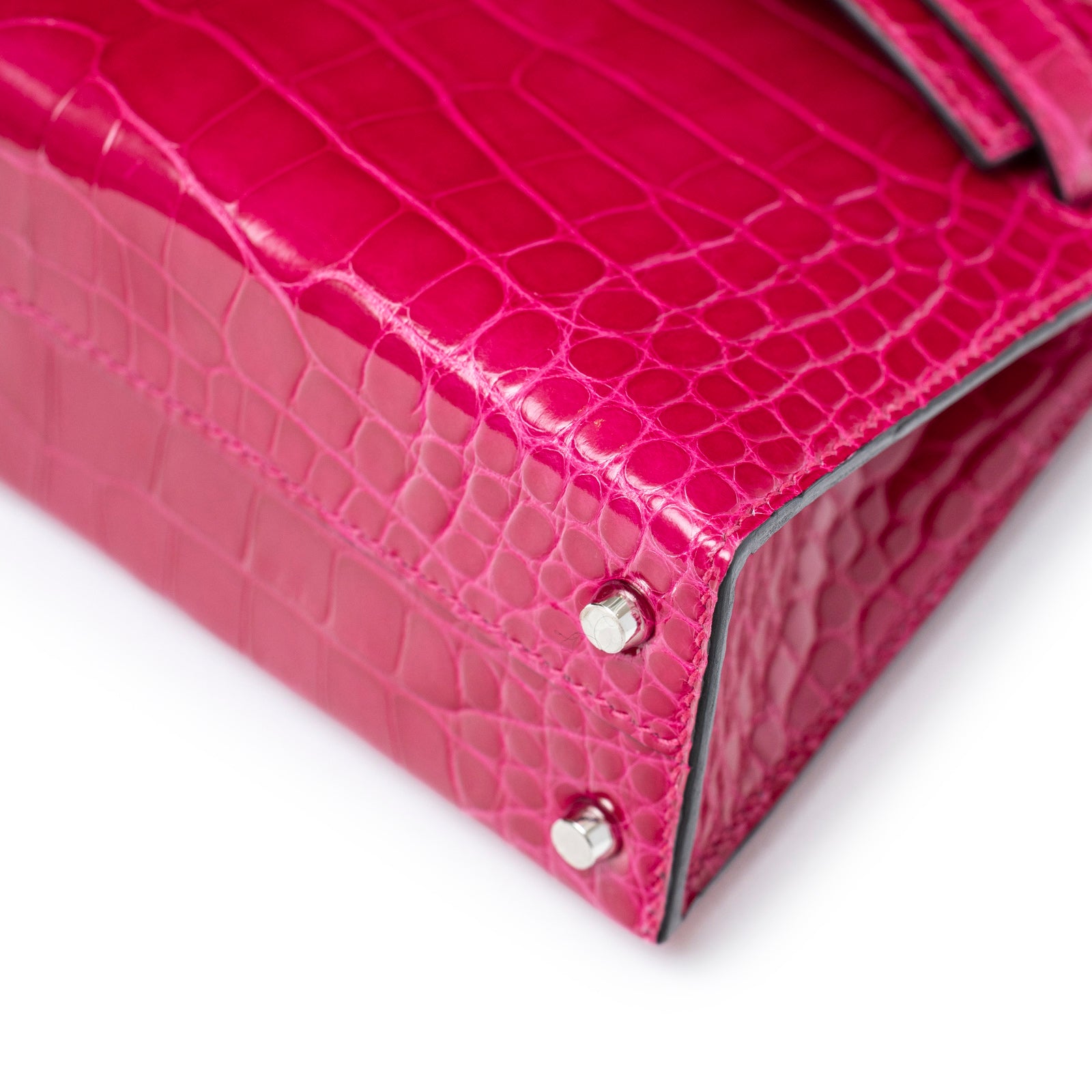 Close-up of bottom corner and palladium hardware feet on Hermès Mini Kelly II Sellier 20 Rose Mexico Shiny Alligator Palladium Hardware