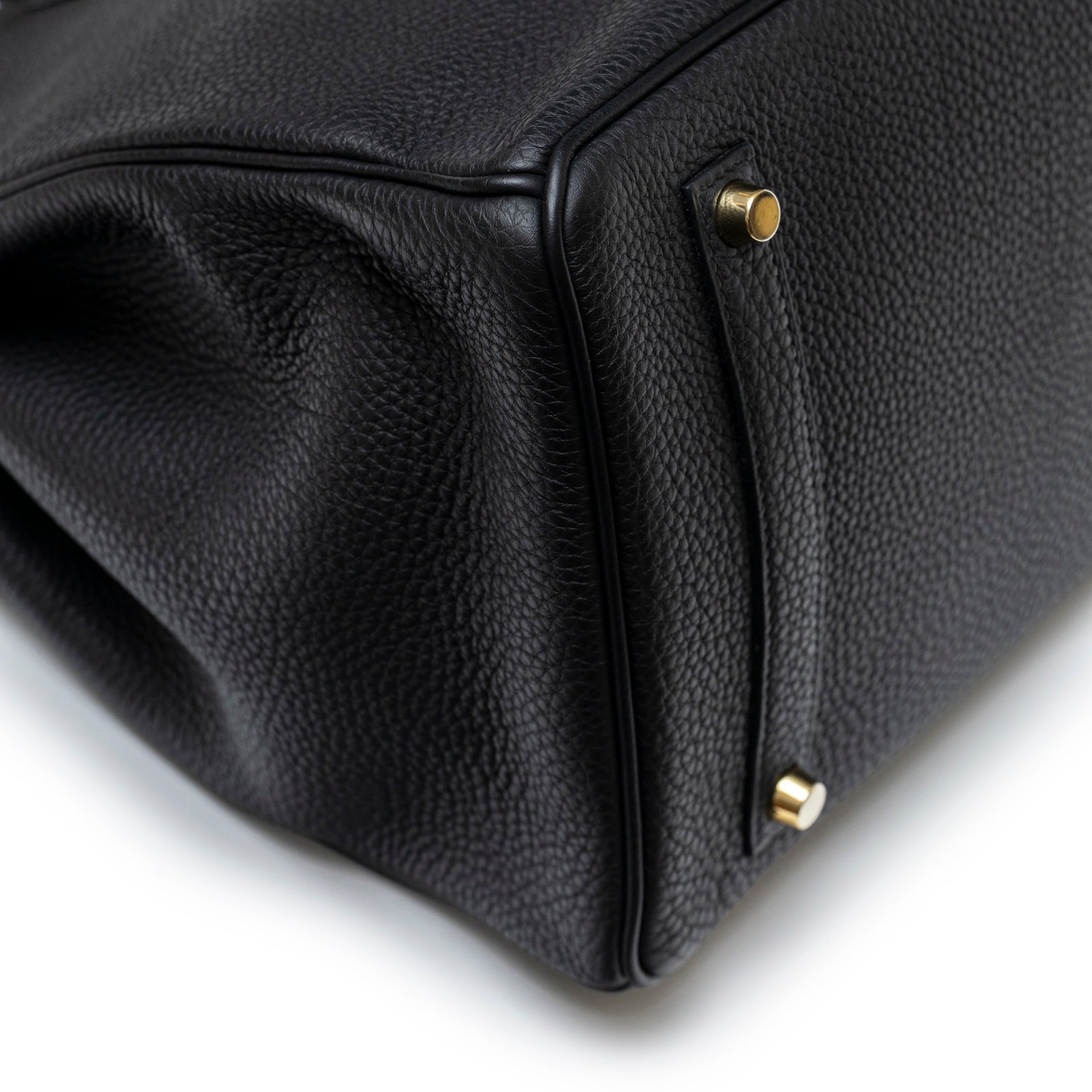 Close-up of bottom corner and gold hardware feet on Hermès Birkin 35 Black Togo Gold Hardware bag showing texture