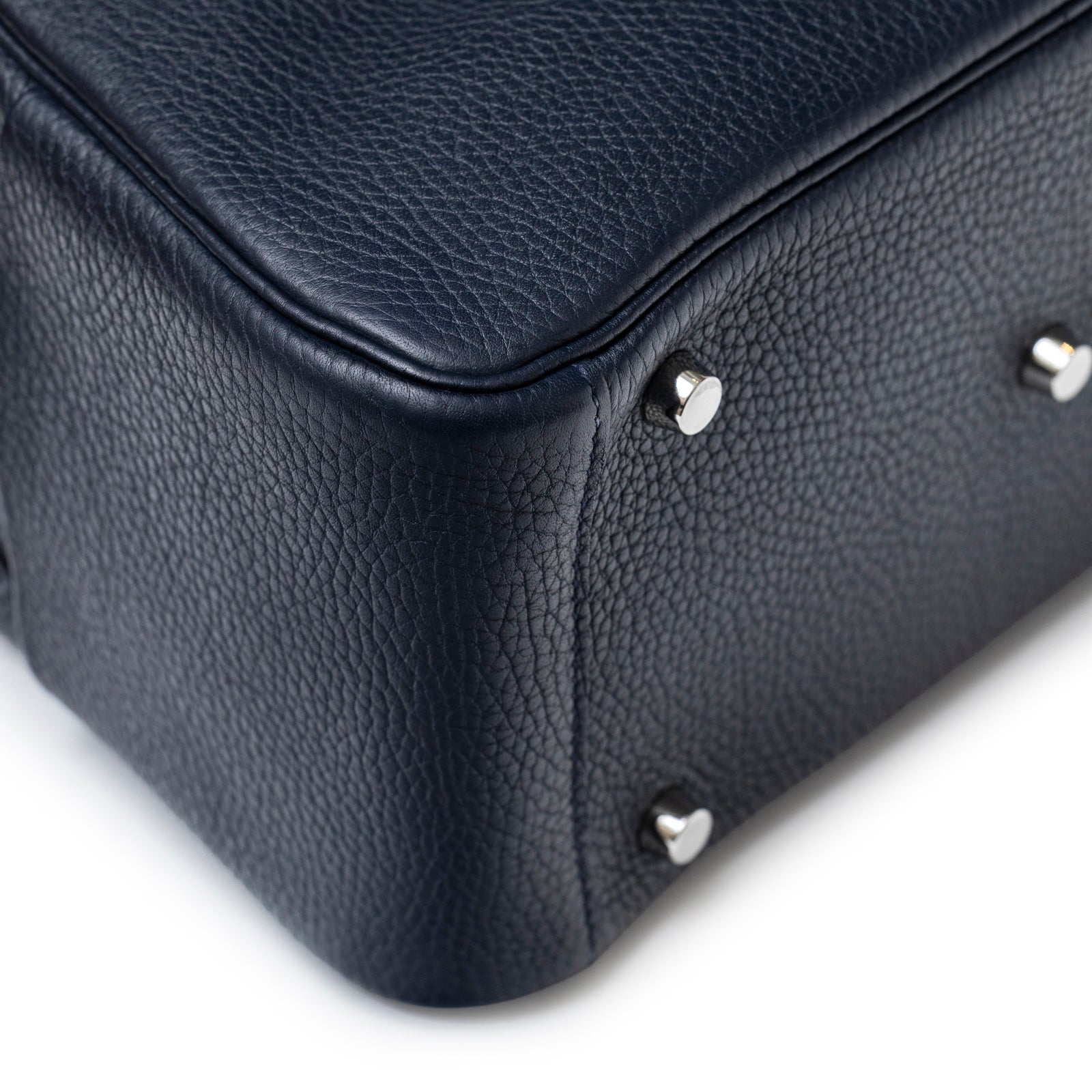 Close-up of bottom corner and palladium feet on Hermès Lindy 26 Blue Nuit Clemence Palladium Hardware bag