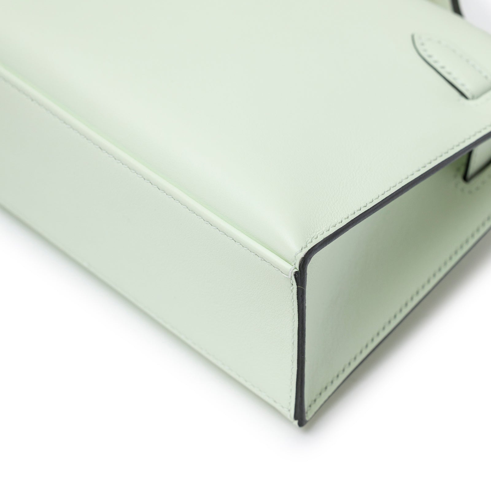Close-up of bottom corner on Hermès Kelly Pochette Vert Fizz Swift Palladium Hardware showing smooth leather and edge detail