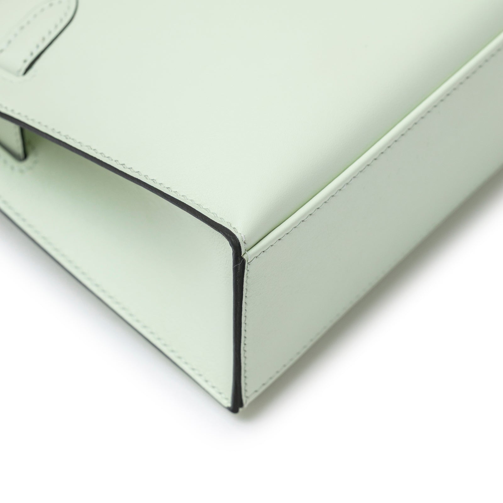 Close-up of bottom corner and edge stitching on Hermès Kelly Pochette Vert Fizz Swift Palladium Hardware bag