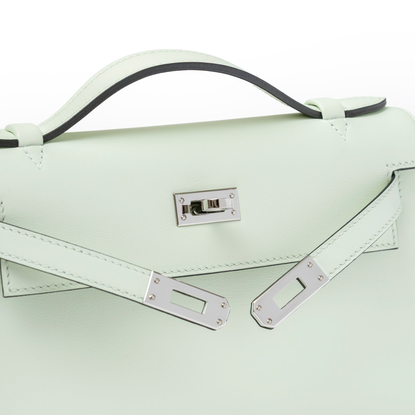 Close-up of Hermès Kelly Pochette Vert Fizz Swift Palladium Hardware showing top handle and clasp detail
