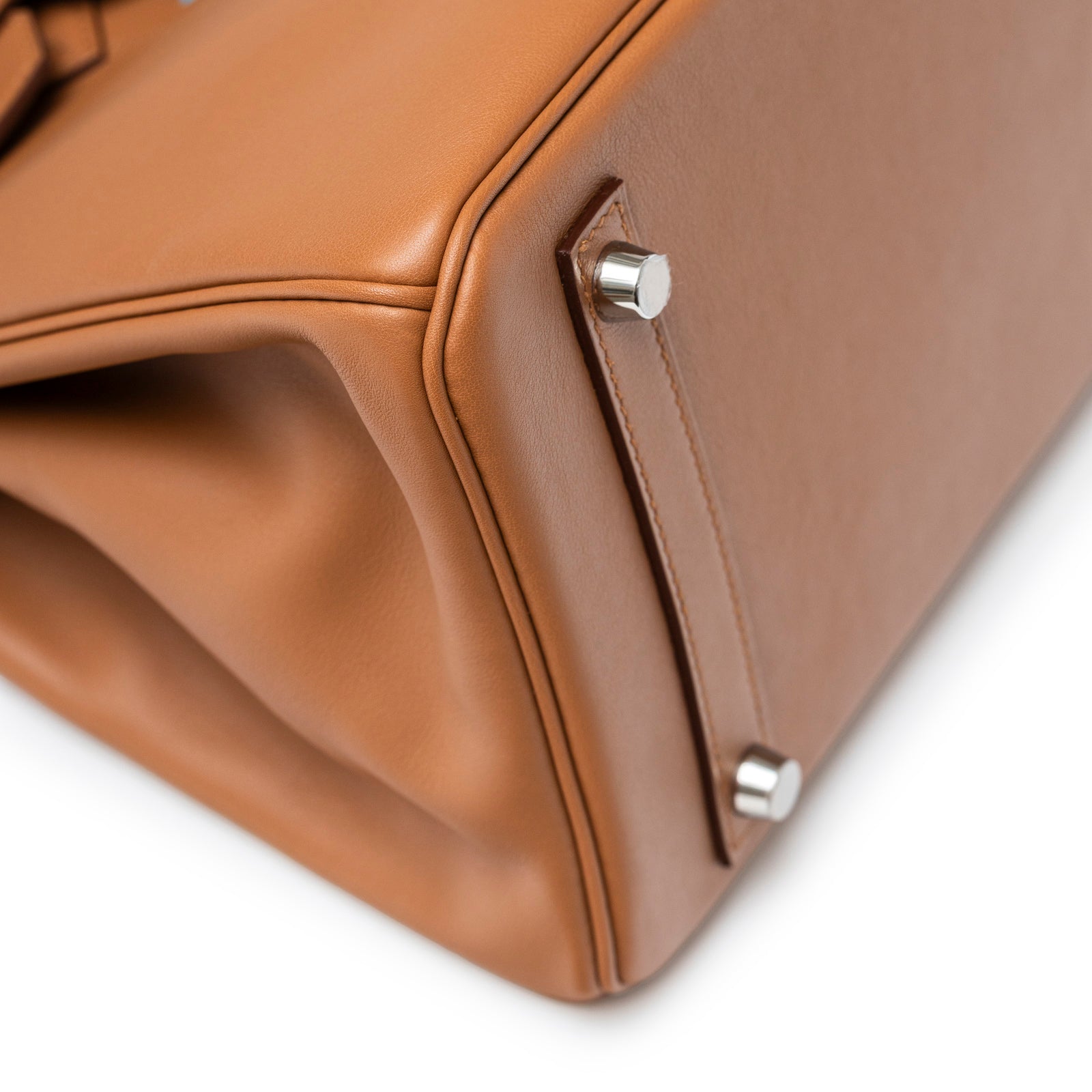 Close-up of the bottom corner and palladium hardware feet on Hermès Birkin 30 Tressage Gold/Blue Du Nord/Blue Indigo Swift/Epsom Palladium Hardware bag