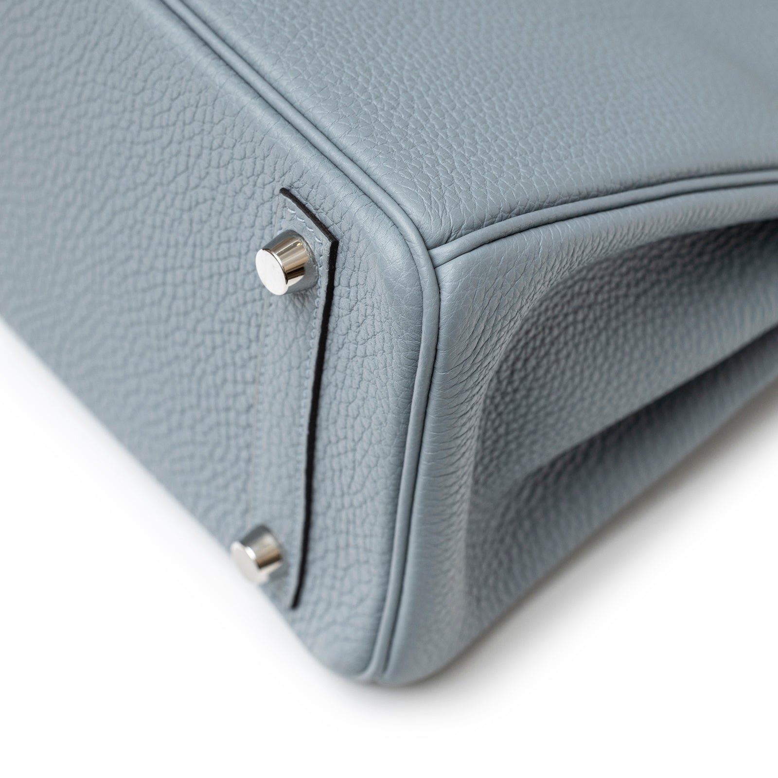 Close-up of bottom corner and palladium feet on Hermès Birkin 25 Blue Lin Verso Beige De Weimar Togo Palladium Hardware bag