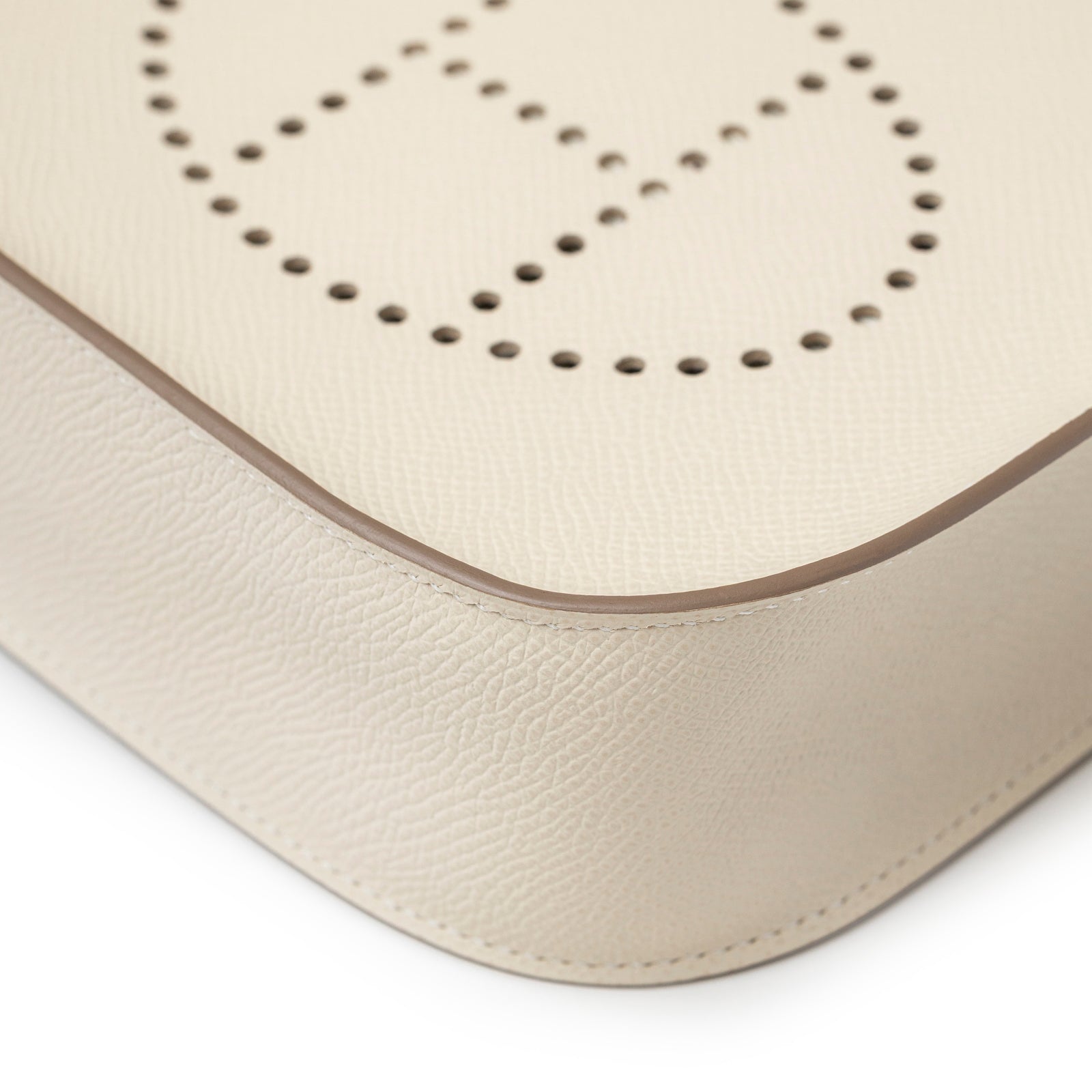 Close-up of corner and perforated logo detail on Hermès Mini Evelyne Sellier Craie Epsom Gold Hardware bag