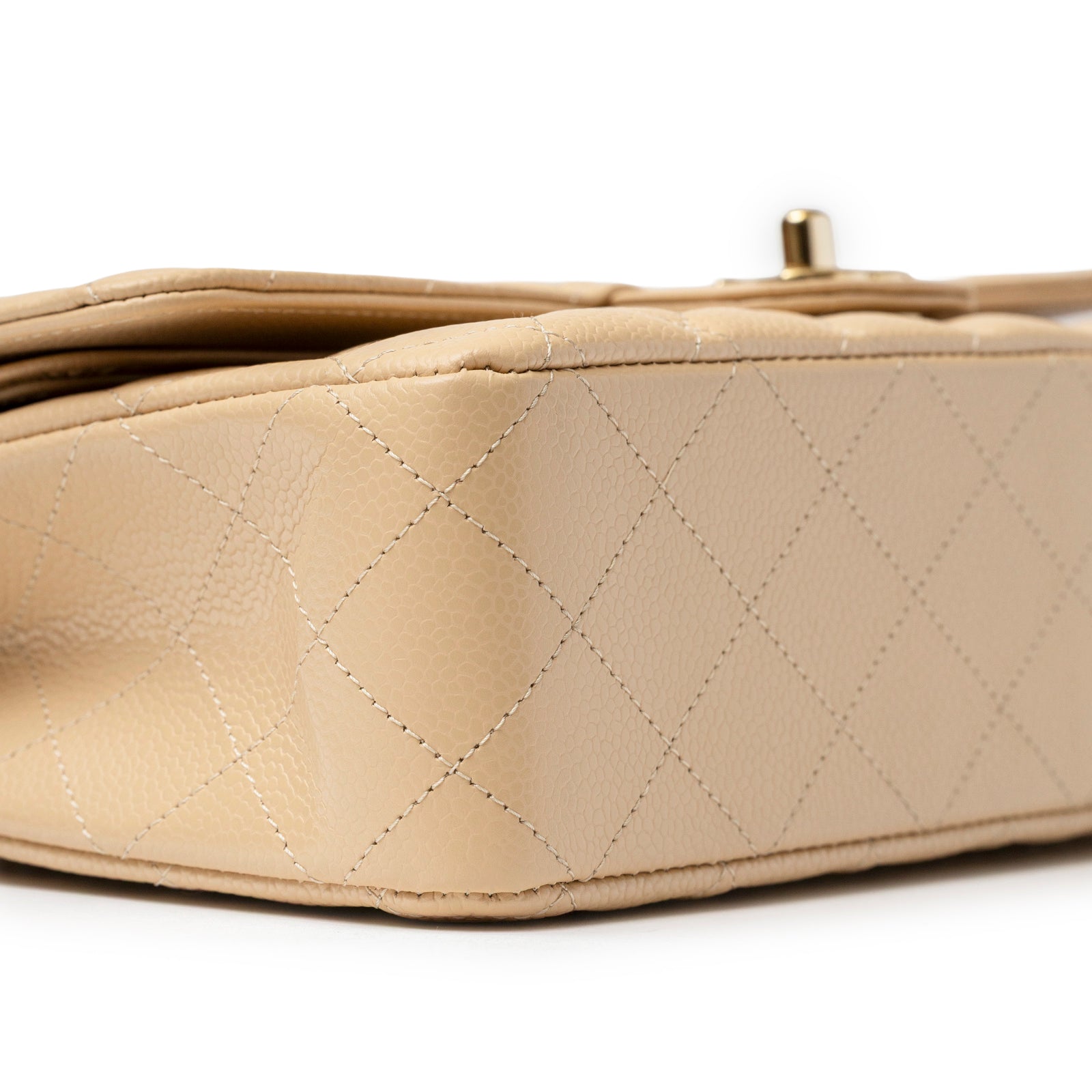 Close-up bottom view of Chanel Classic Flap Medium Caviar Beige Gold Hardware showing quilted leather texture and stitching detail.