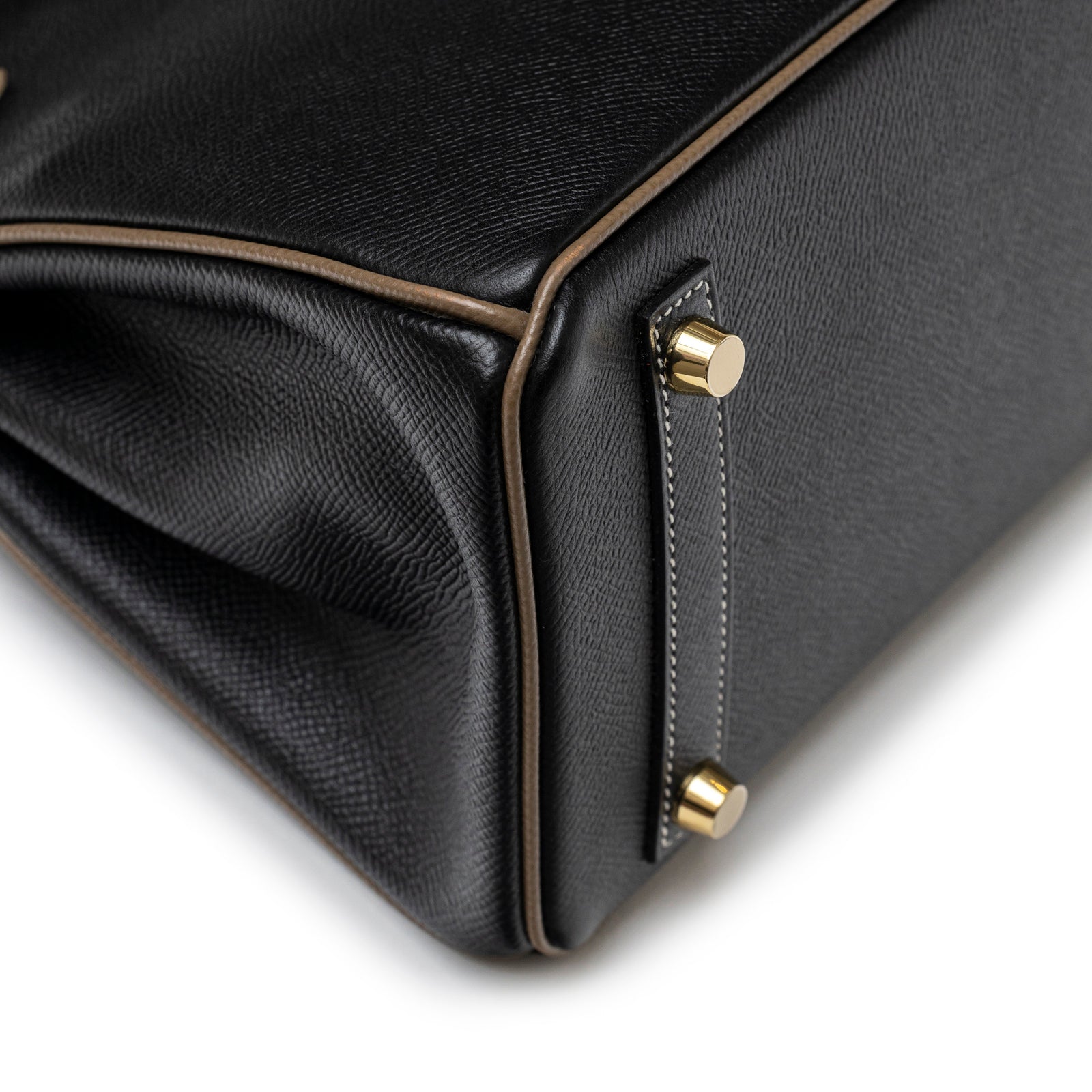 Close-up angled view of base corner with gold hardware and contrast Etoupe piping on Hermès Special Order HSS Horseshoe Birkin 25 Black/Etoupe Epsom Gold Hardware