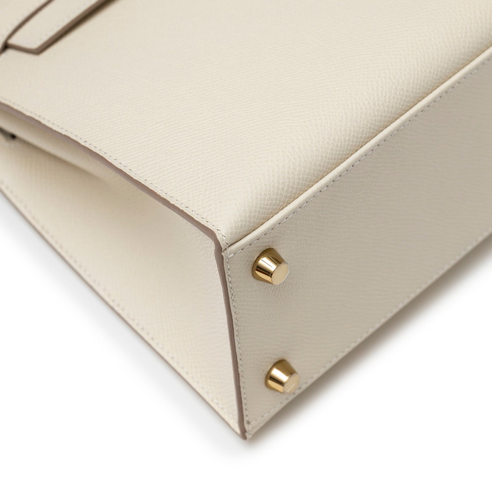 Close-up angled view of base hardware and corner stitching on Hermès Kelly 25 Sellier Epsom Craie Permabrass Hardware