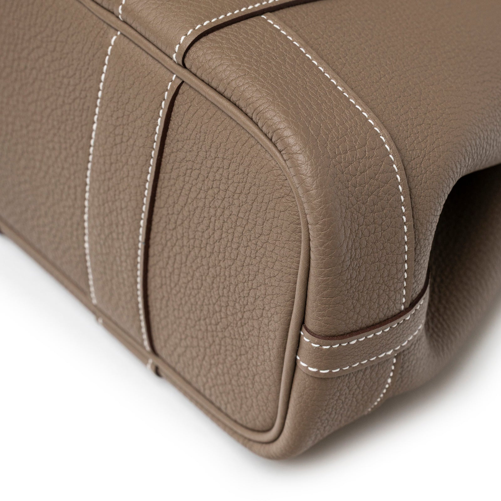 Close-up of Hermès Mini Garden Party Neo 23 Etoupe Negonda Palladium Hardware leather corner with white stitching detail