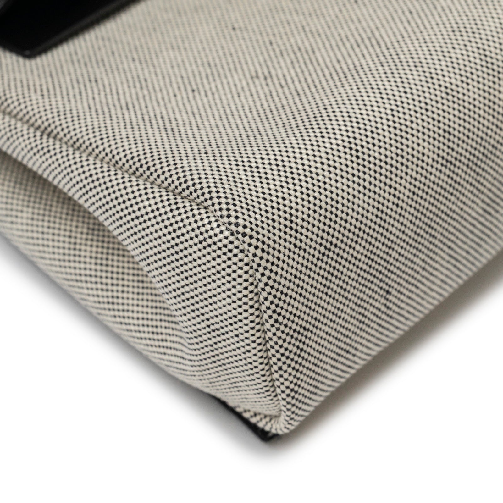 Close-up angled view of Hermès Mini Herbag Zip 20 Ecru/Black Toile and Vache Hunter Palladium Hardware canvas corner detail