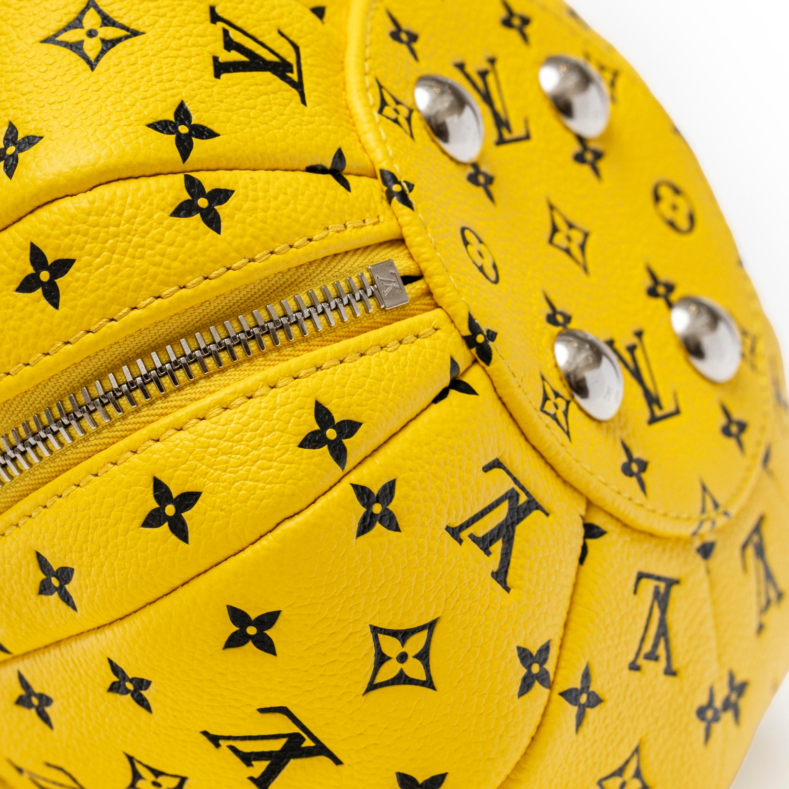 Close-up angled view of Louis Vuitton X Yayoi Kusama Limited Edition Yellow/Black Leather Pumpkin Bag zipper and palladium studs detail