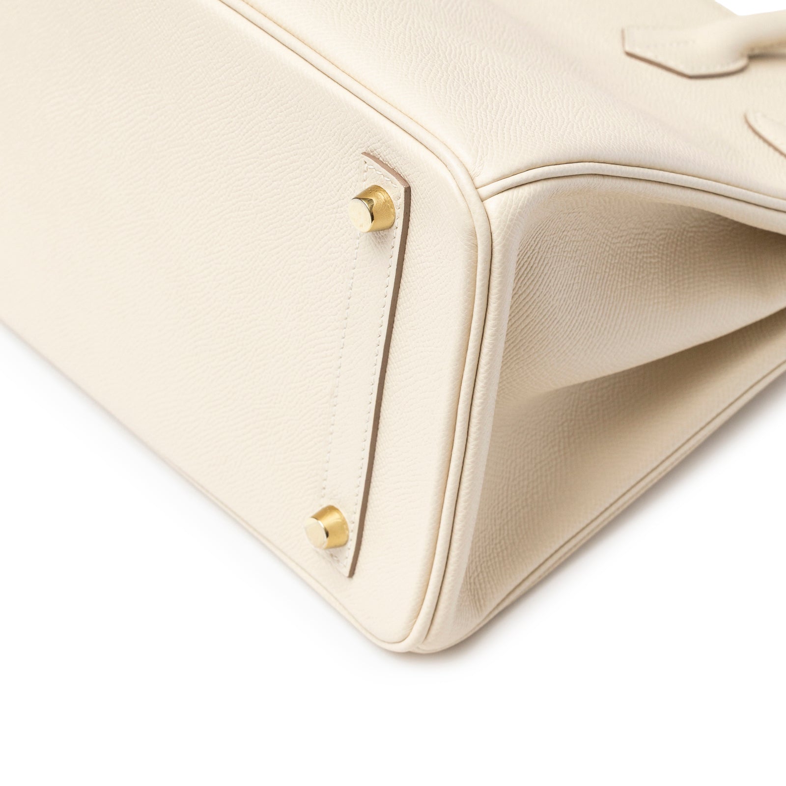 Close-up of bottom corner with gold feet of Hermès Birkin 30 Craie Epsom Gold Hardware showing textured leather and stitching