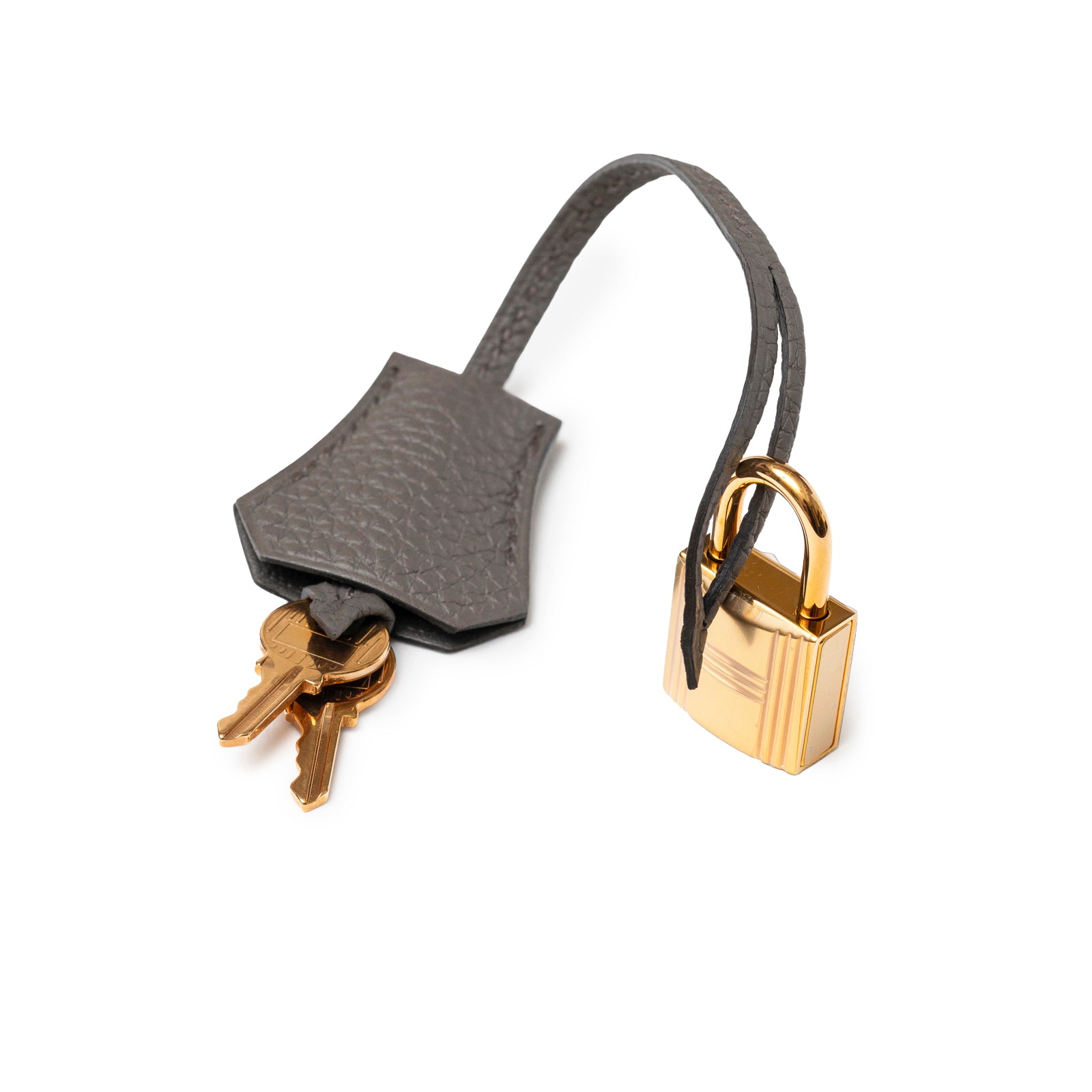 Close-up of Hermès Birkin 25 Etain Togo Rose Gold Hardware lock and keys with leather clochette in white background