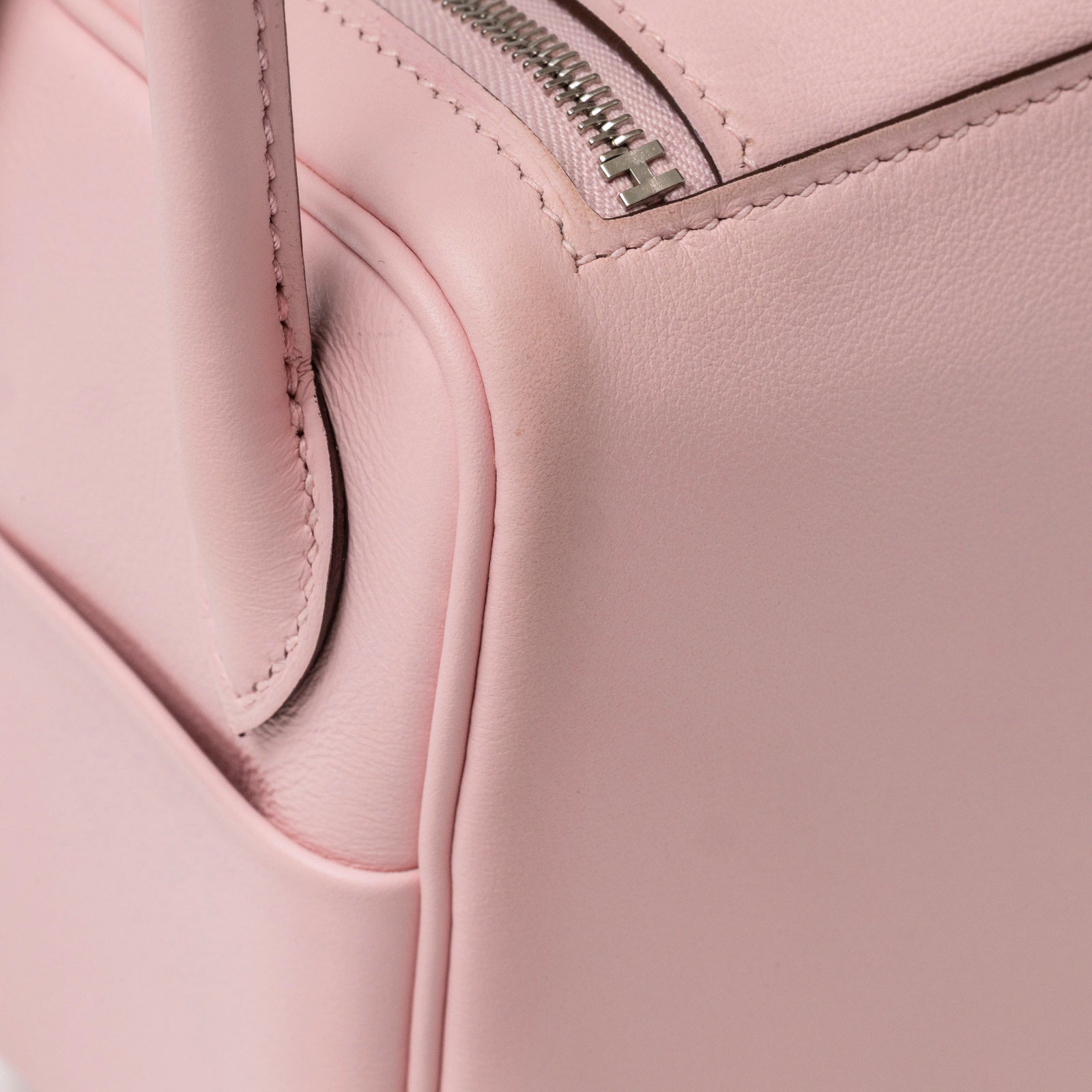 Close-up side view of Hermès Mini Lindy II Rose Sakura Swift Palladium Hardware corner stitching and zipper detail