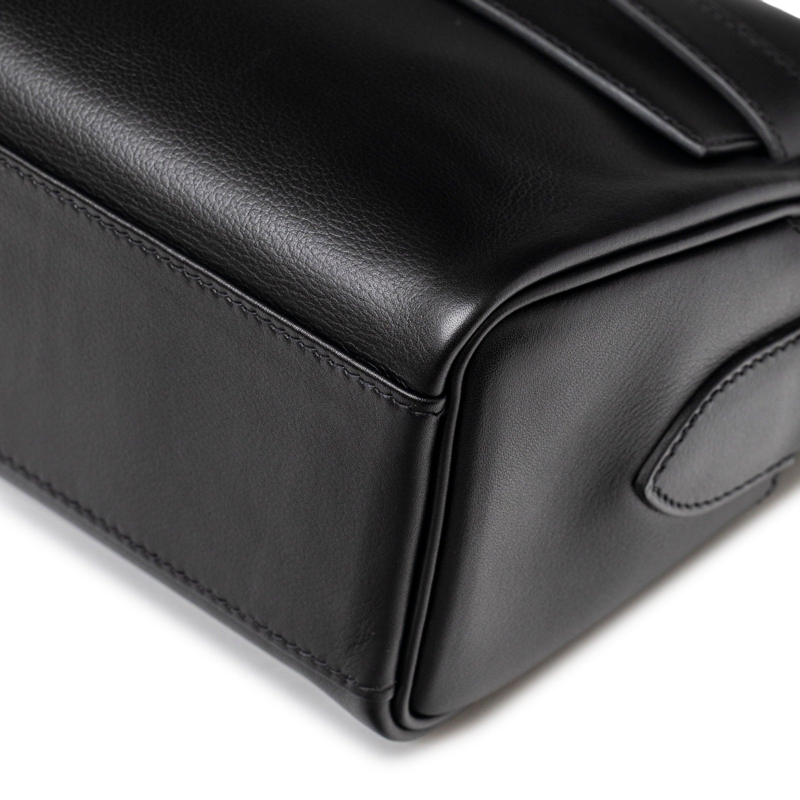 Close-up of bottom corner showing smooth texture on Hermès Kelly Messenger PM Black Evergrain Palladium Hardware