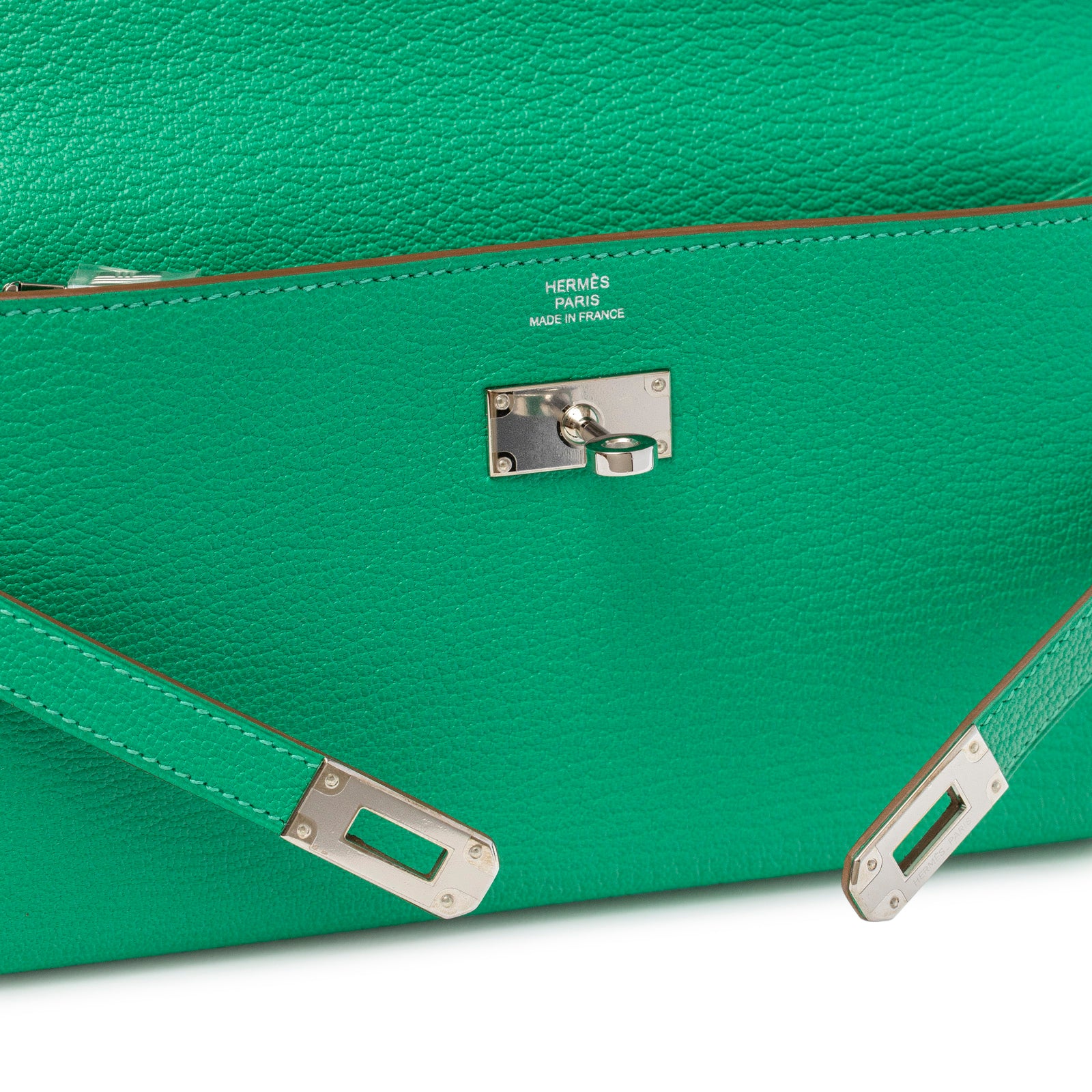 Close-up of Hermès Kelly Long Wallet Menthe Chevre Mysore Palladium Hardware lock and textured green leather detail