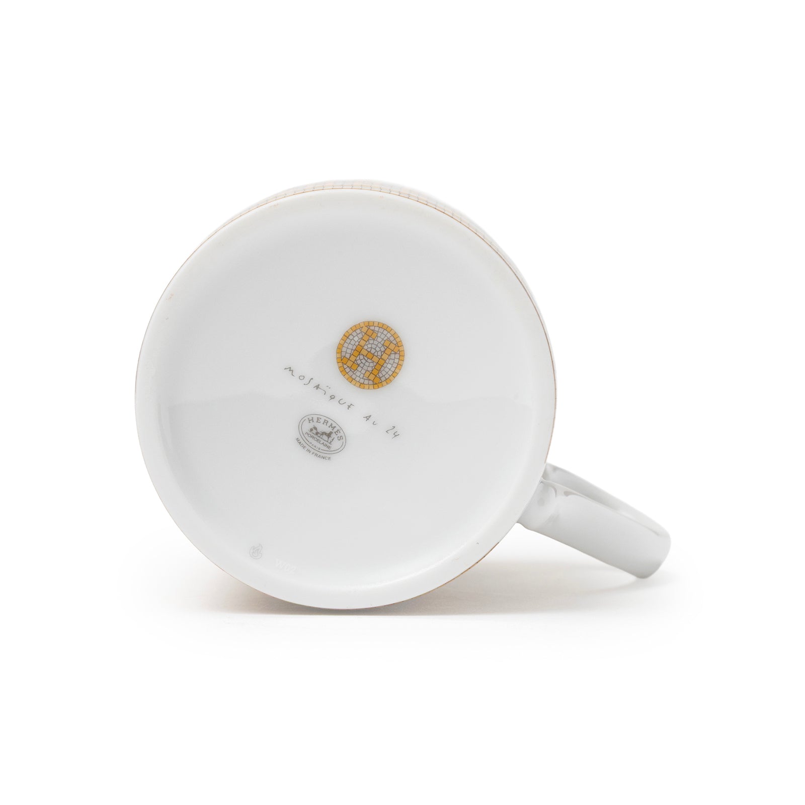 Bottom view of Hermès Mosaique au 24 Gold Mug showing logo and markings on white porcelain base