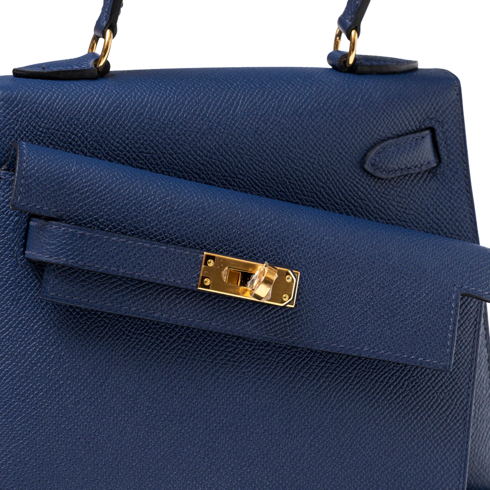 Close-up front view of Hermès Kelly Desordre 20 Sellier Blue Saphir Epsom Gold Hardware clasp detail