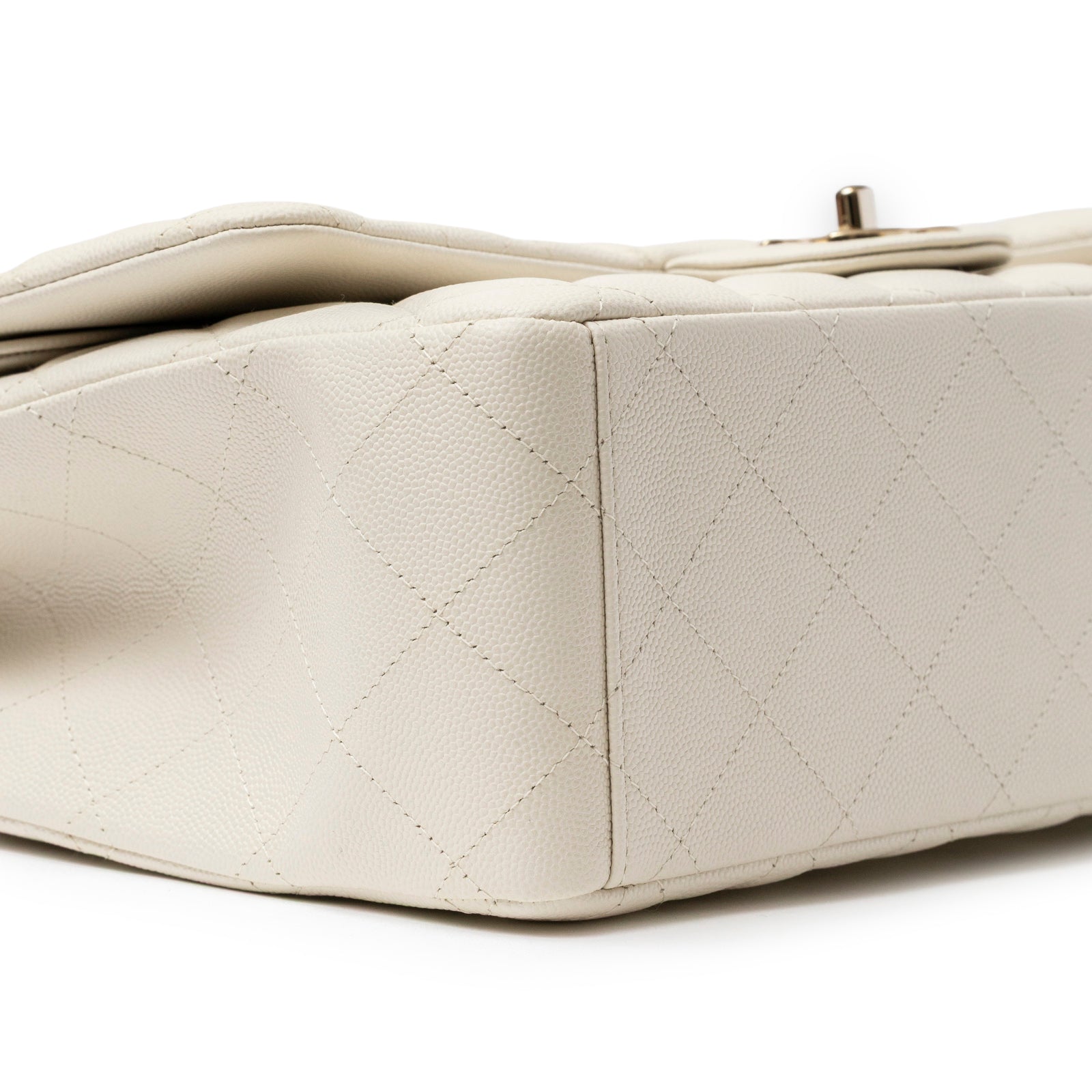 Close-up angled shot of Chanel Classic Flap Maxi Caviar White Gold Hardware showing textured leather and stitching detail on base