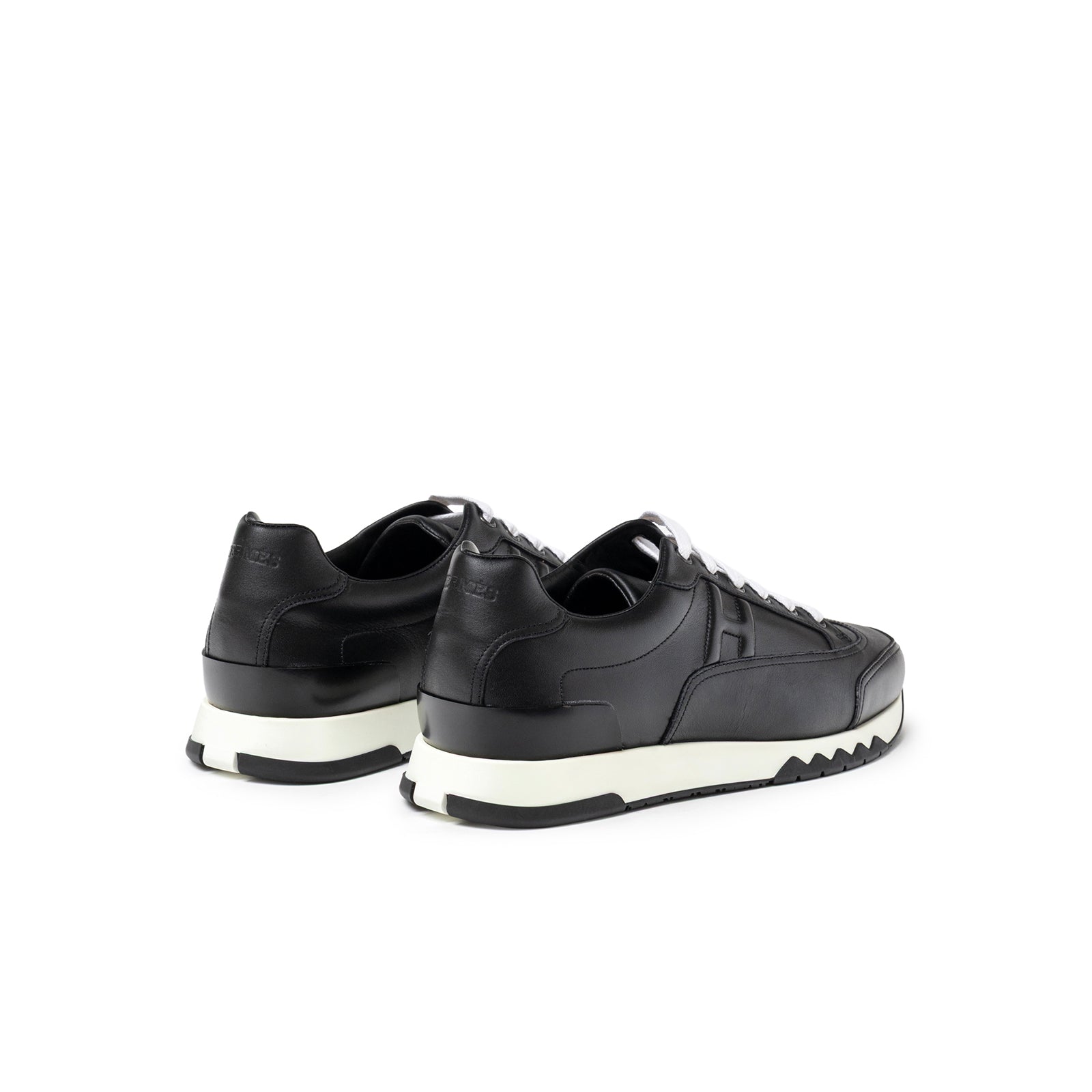 Rear angled view of Hermès Men's Trail Sneaker Black showing black leather upper and white sole details