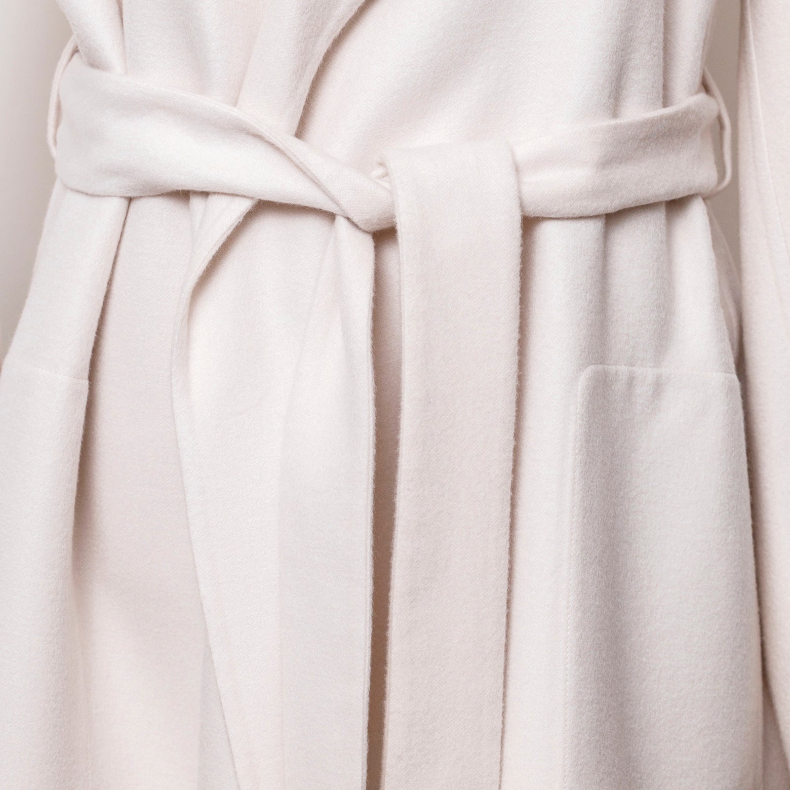 Close-up front view of Hermès Manteau Esprit Peignoir Cashmere Doubleface Coat belt and pocket details in ivory tone
