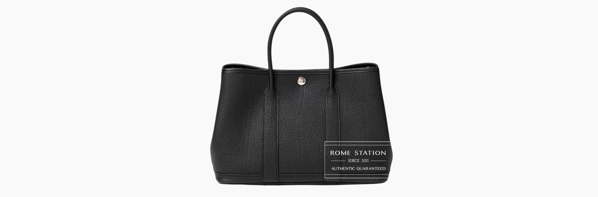 Black leather handbag with handles.