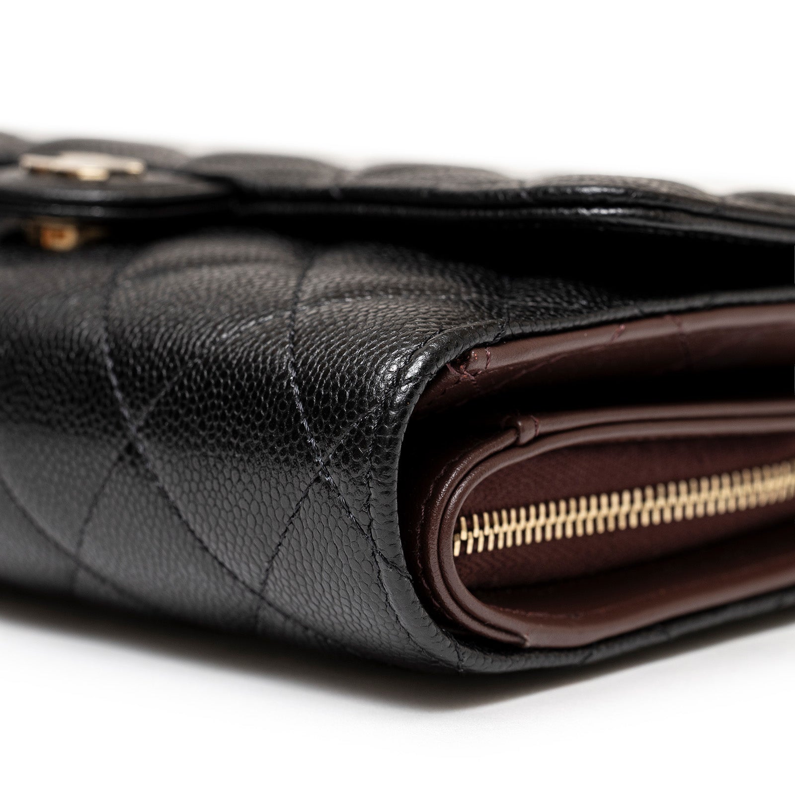 Close-up side view of Chanel 24S Classic Clutch On Chain Caviar Black Gold Hardware showing texture and zipper detail