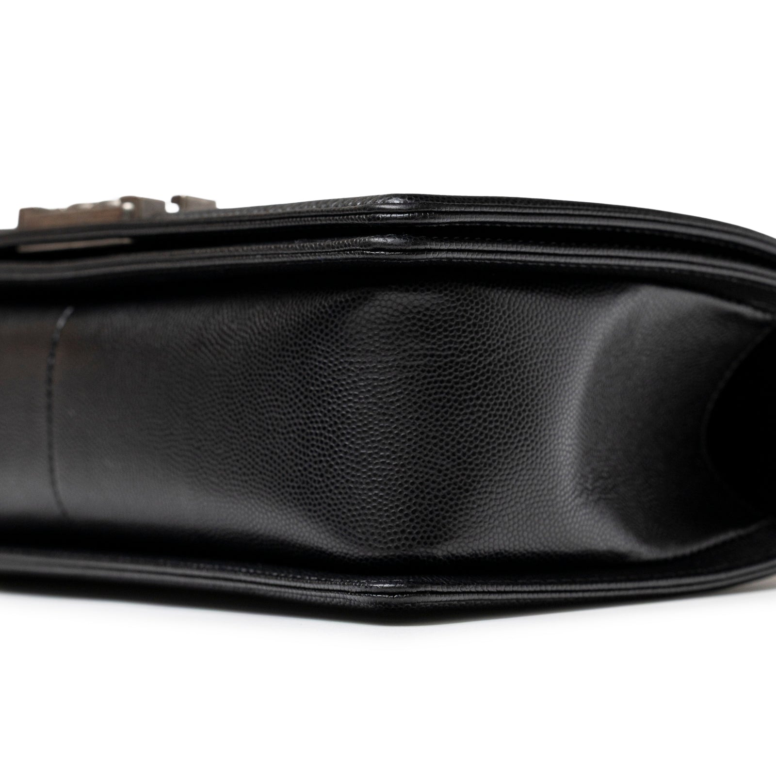 Close-up side view of Chanel Boy Bag Medium Black Caviar Aged Ruthenium Hardware showing textured leather detail.
